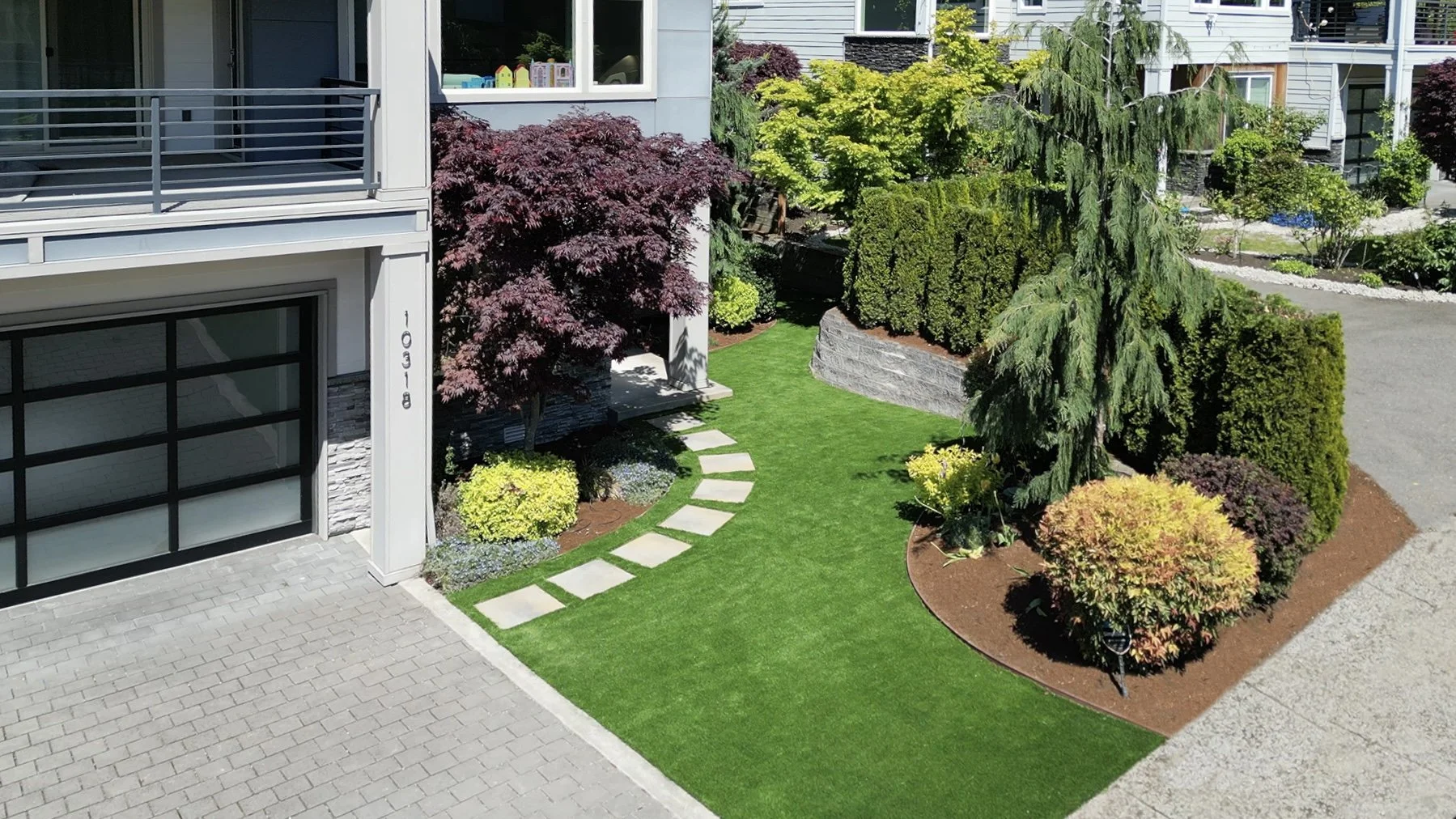Artificial turf and stepping stone pathway in Clyde Hill creating a modern front yard design.
