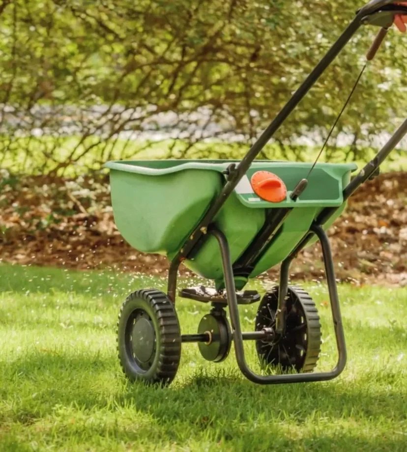 Overseeding equipment spreading new grass seed during landscaping in Seattle, WA