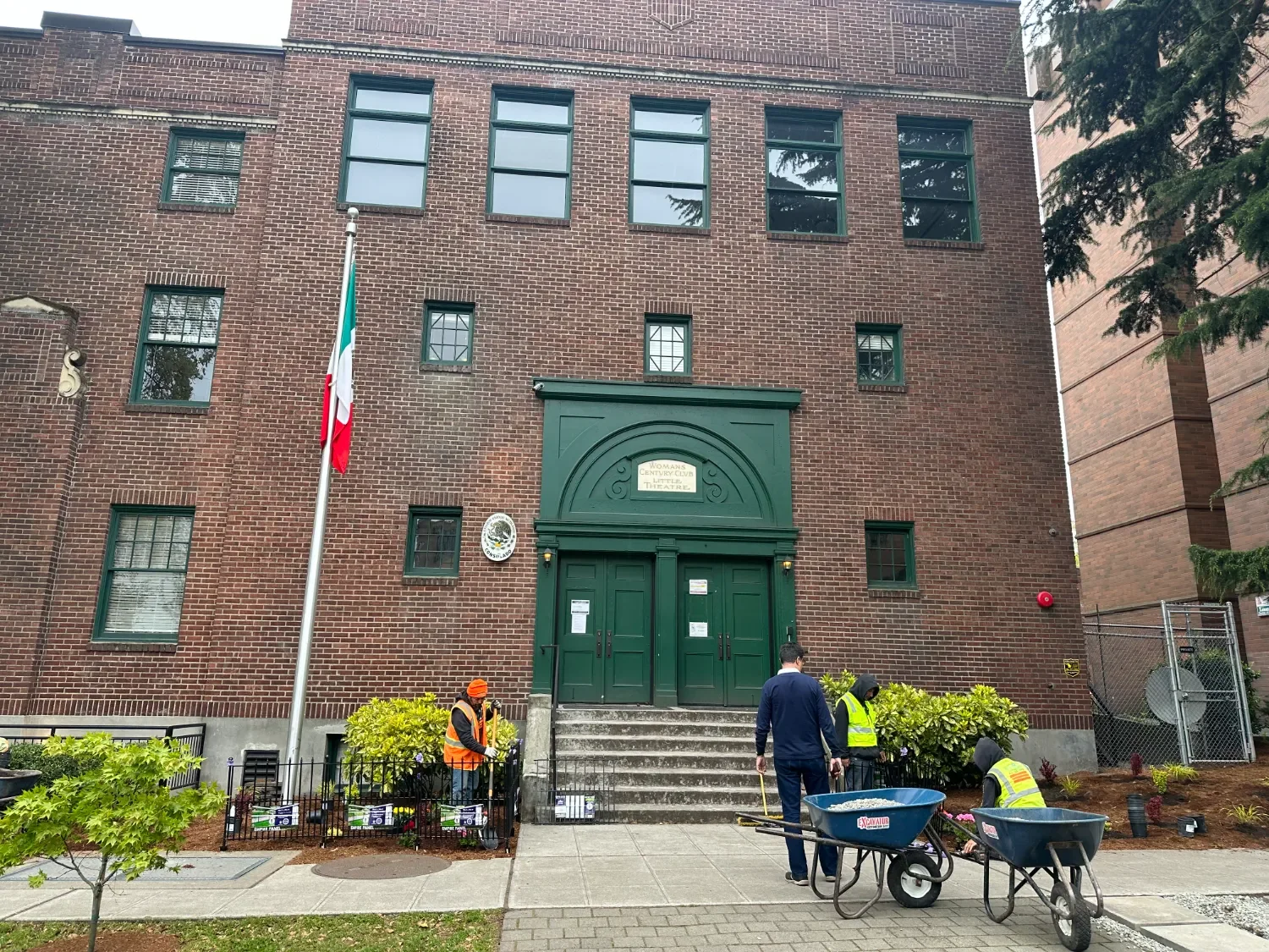 Uniformed commercial landscaping crew planting and mulching at a Seattle, WA commercial property