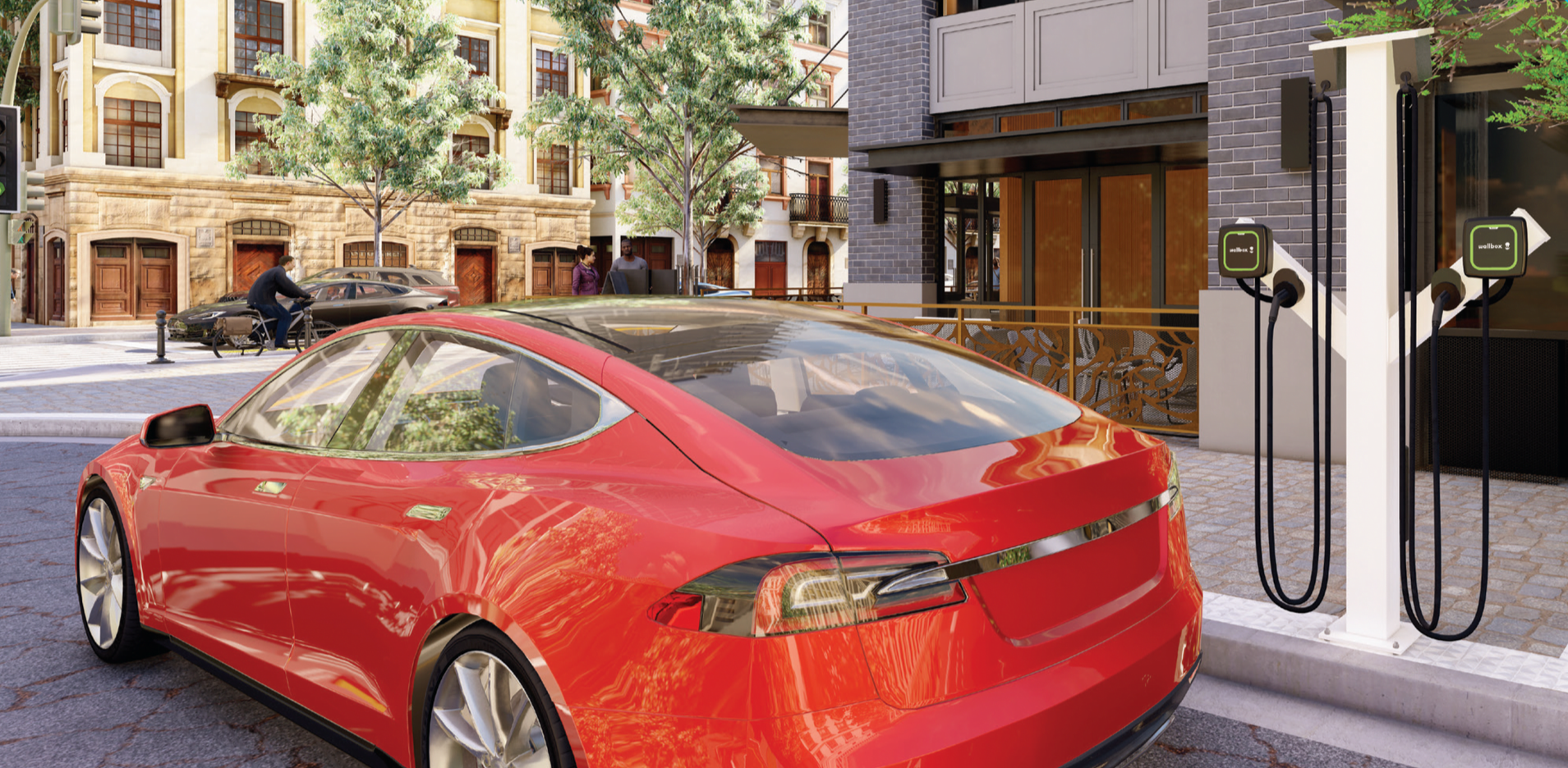 A red electric car parked at a charging station on a city street, with buildings, trees, and pedestrians in the background.