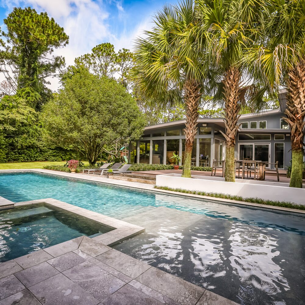 Outdoor living poolscape with modern hardscaping in Wilmington, NC
