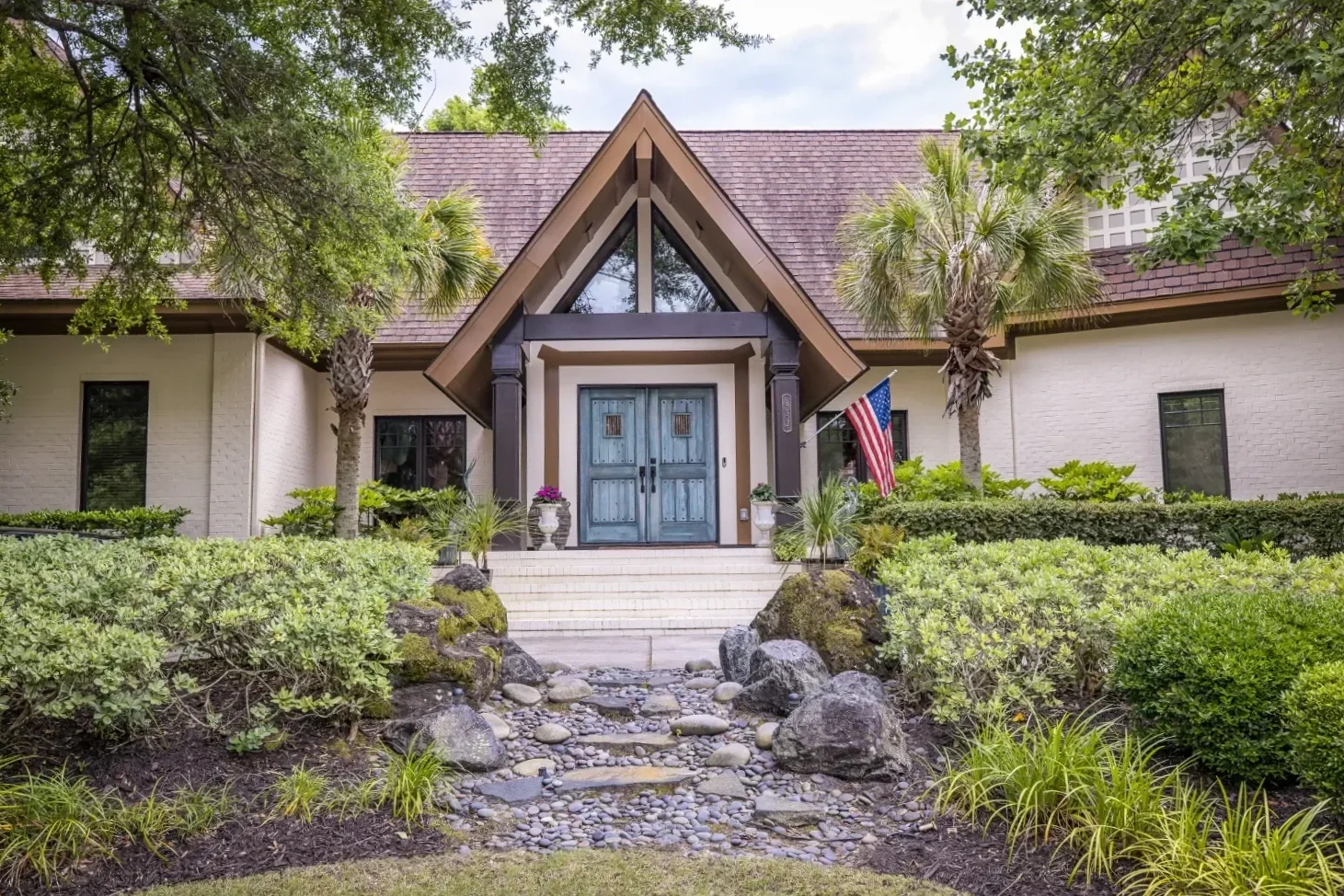 Outdoor living entry with stone steps and mature plantings in Hampstead, NC
