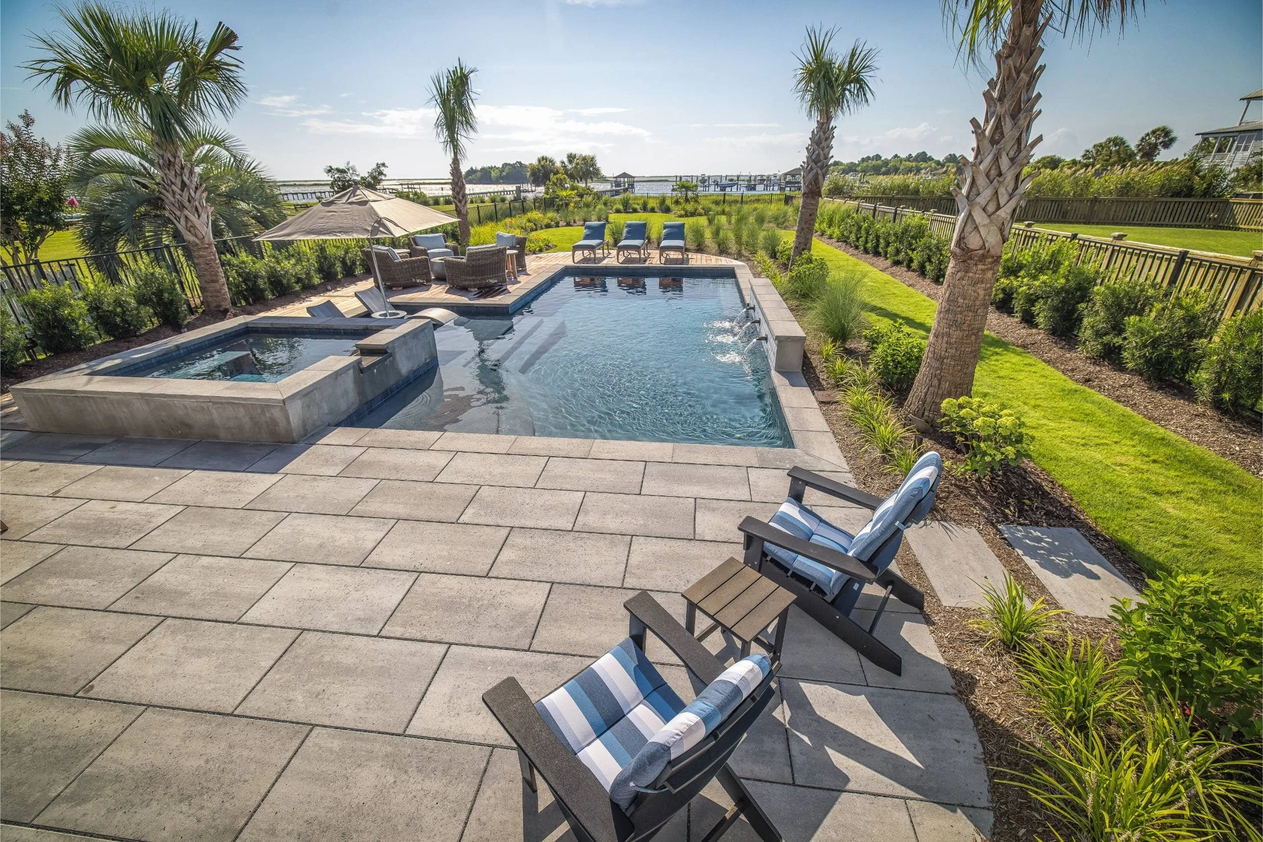 A custom pool builder near me installation with expansive terrace in Wilmington, NC