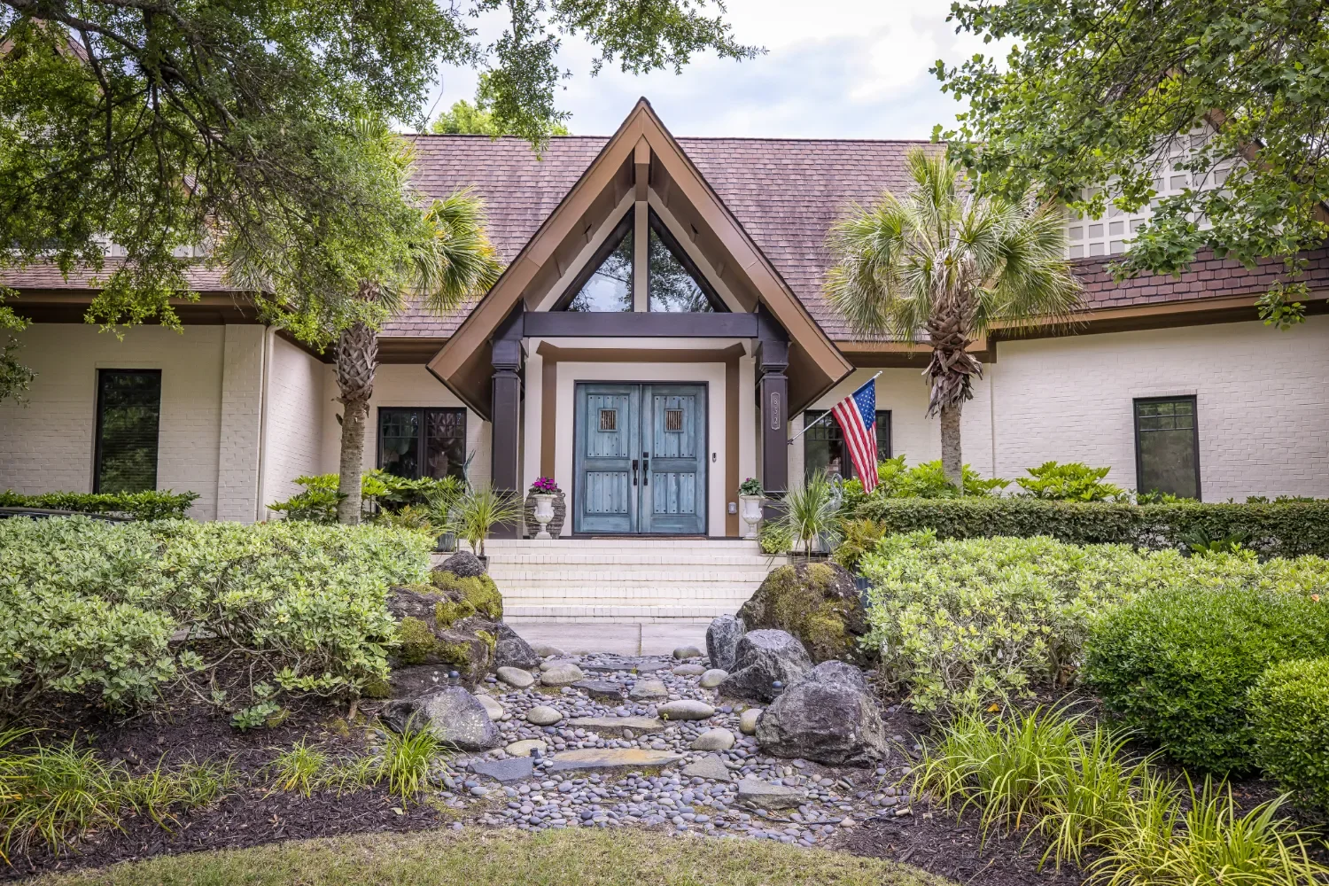 Outdoor living entry with stone steps and mature plantings in Hampstead, NC