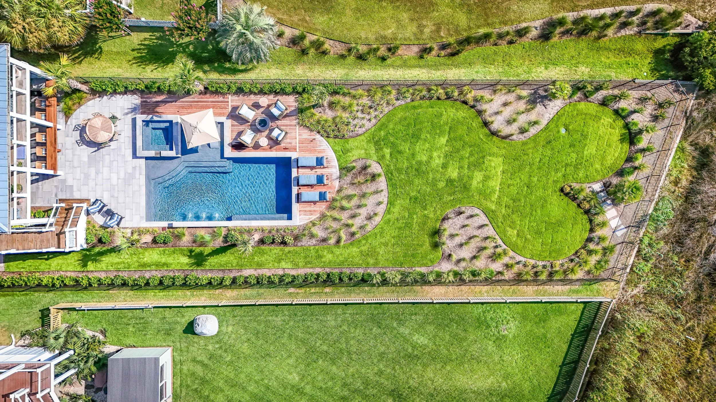 Backyard outdoor living space with patio seating and greenery in Wilmington, NC