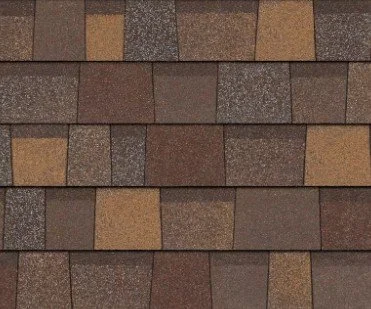 Close-up of a brick or shingle roof with rectangular pieces in brown, tan, and gray tones.