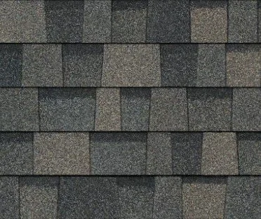 Close-up of a shingled roof with overlapping gray asphalt shingles.