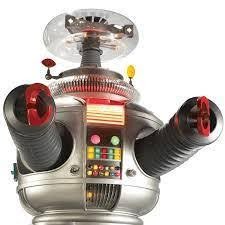 A vintage toy robot with a metallic silver body, red and black arms, and colorful buttons on its chest.