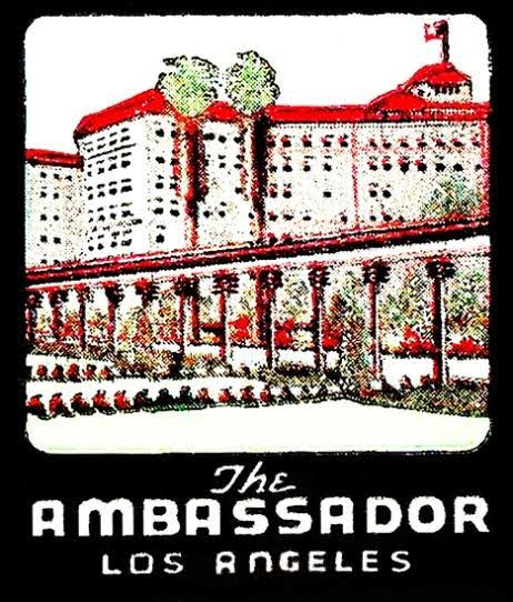 Illustration of a cityscape with tall buildings and steam coming from chimneys, with the text 'The Ambassador Los Angeles' at the bottom.