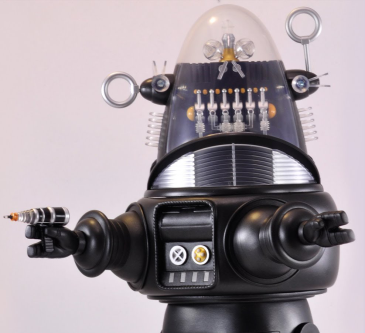 Close-up of a robot toy with a black body, transparent dome head, and various small details, set against a plain background.