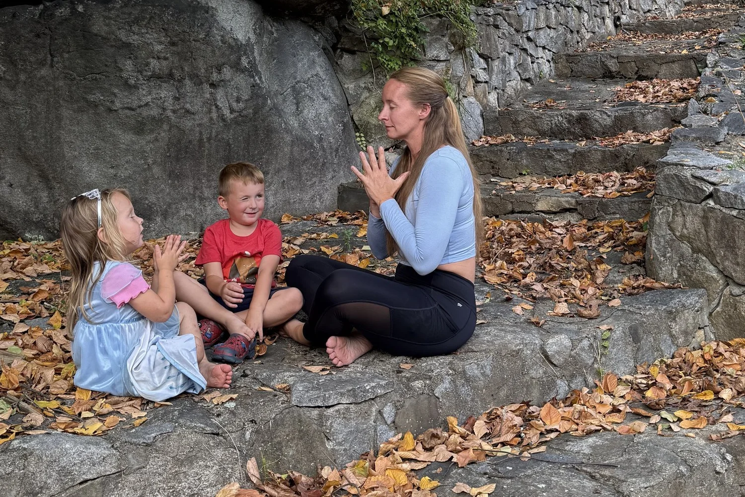 Heather Dana, founder of Lila Within, practicing yoga outdoors with her two kids