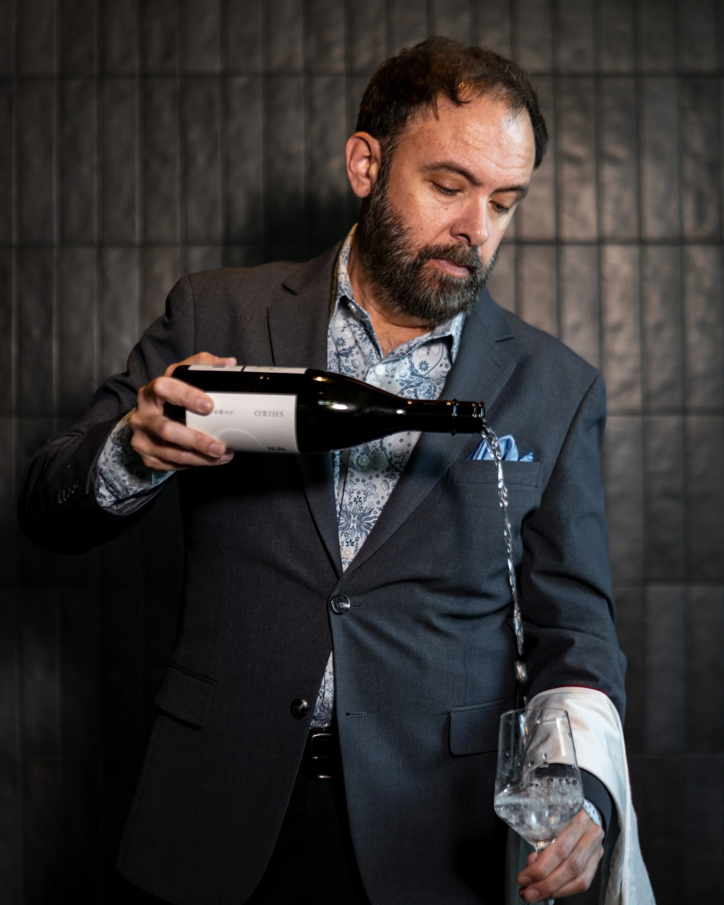 Beverage Director Benjamin Coutts pouring a glass, bringing his 2023 Michelin Sommelier Award-winning wine and sake pairings to Kappo Tsan in Orlando, FL.