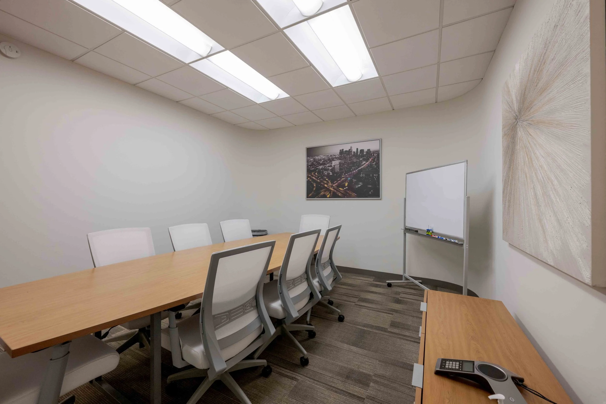 Private meeting room with a large conference table and a large whiteboard in the corner.