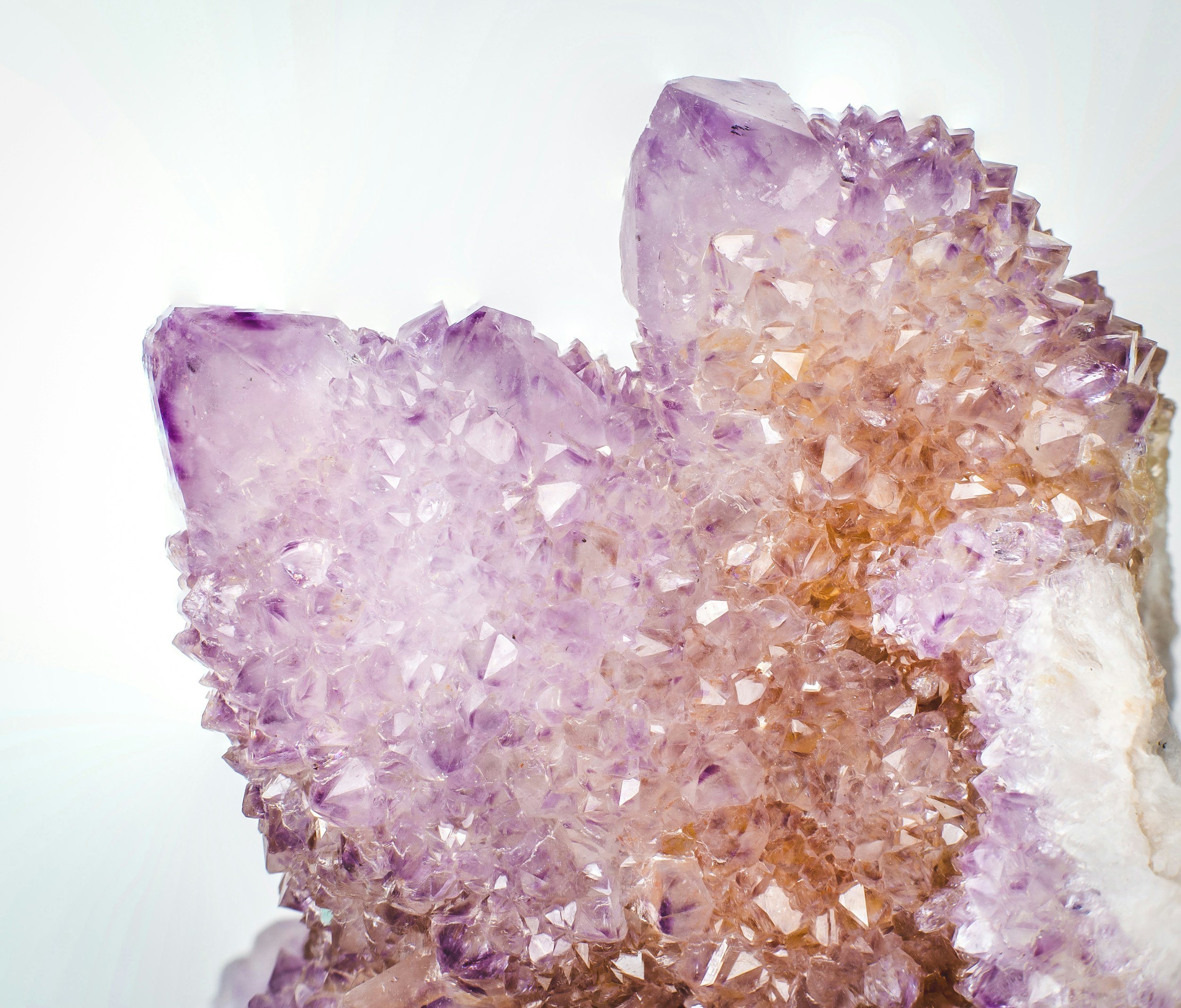 Close-up of a purple and pink crystalline mineral formation, showing detailed sparkly gemstone structures.