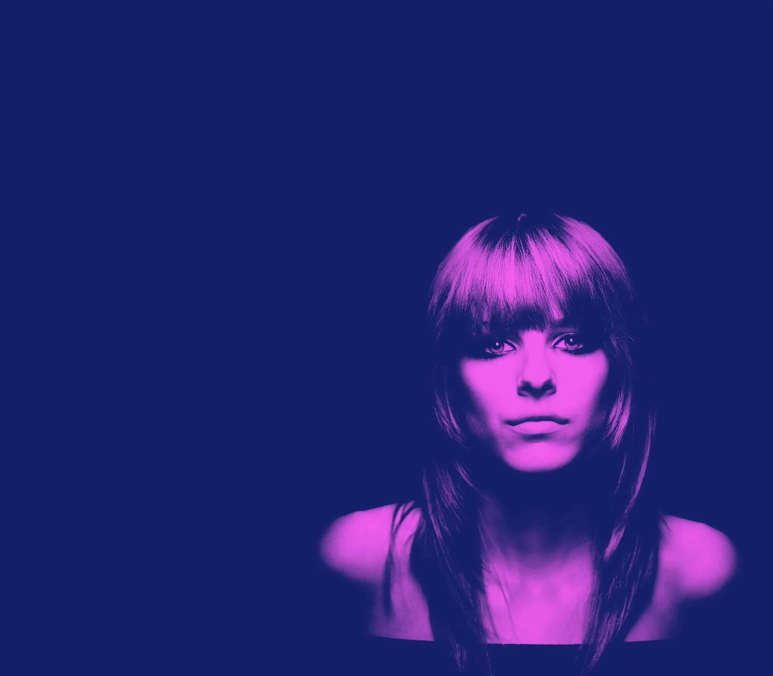 A woman with straight, shoulder-length hair and bangs, face mostly visible, lit with purple and pink lighting against a dark background.