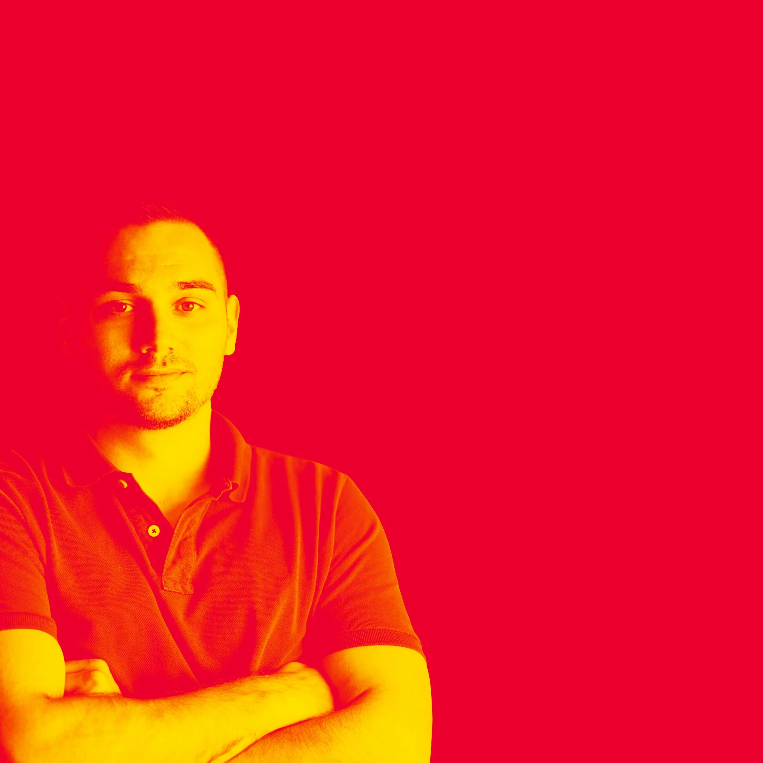 Portrait of a man with crossed arms, wearing a polo shirt, against a solid red background.