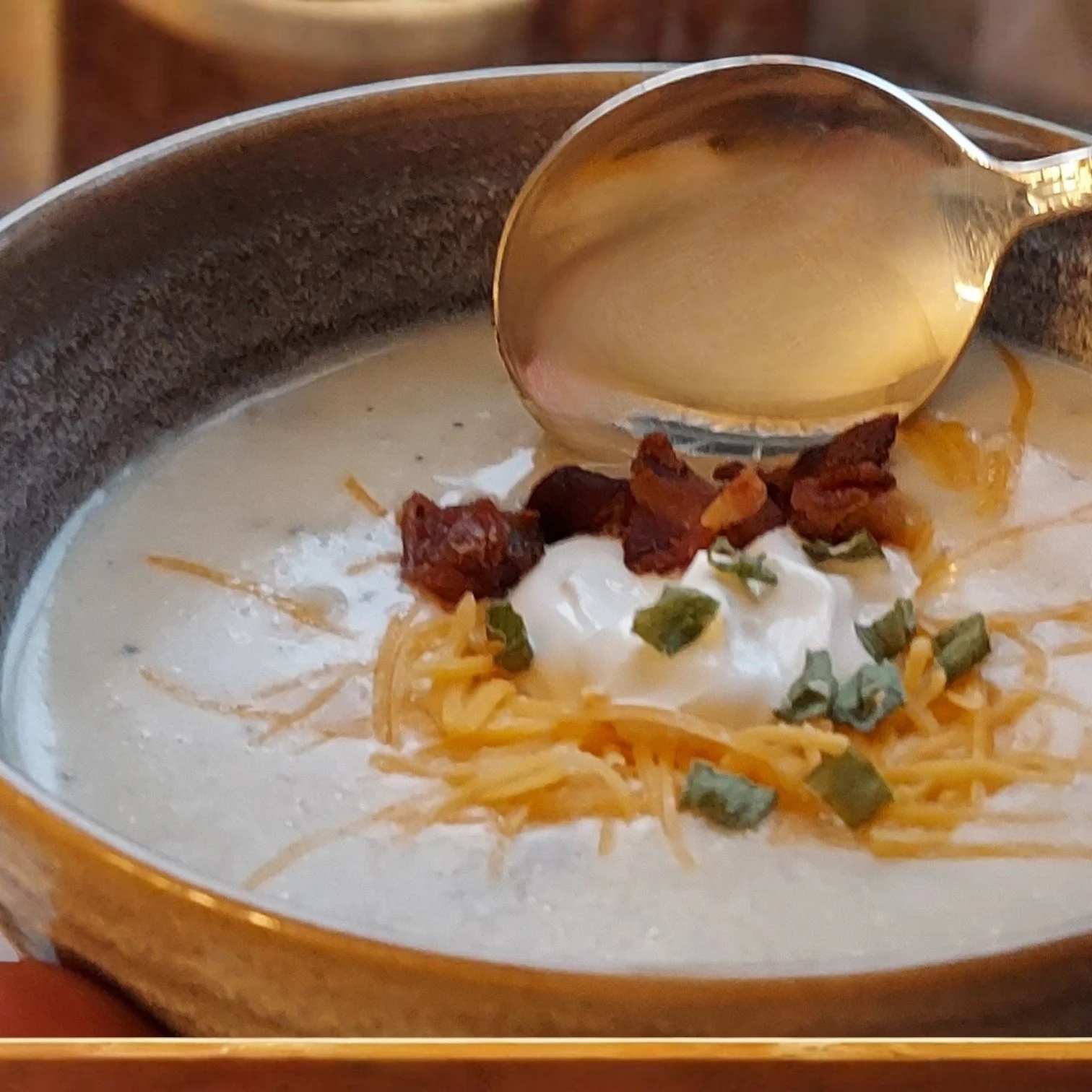 Bowl of potato soup with silver spoon