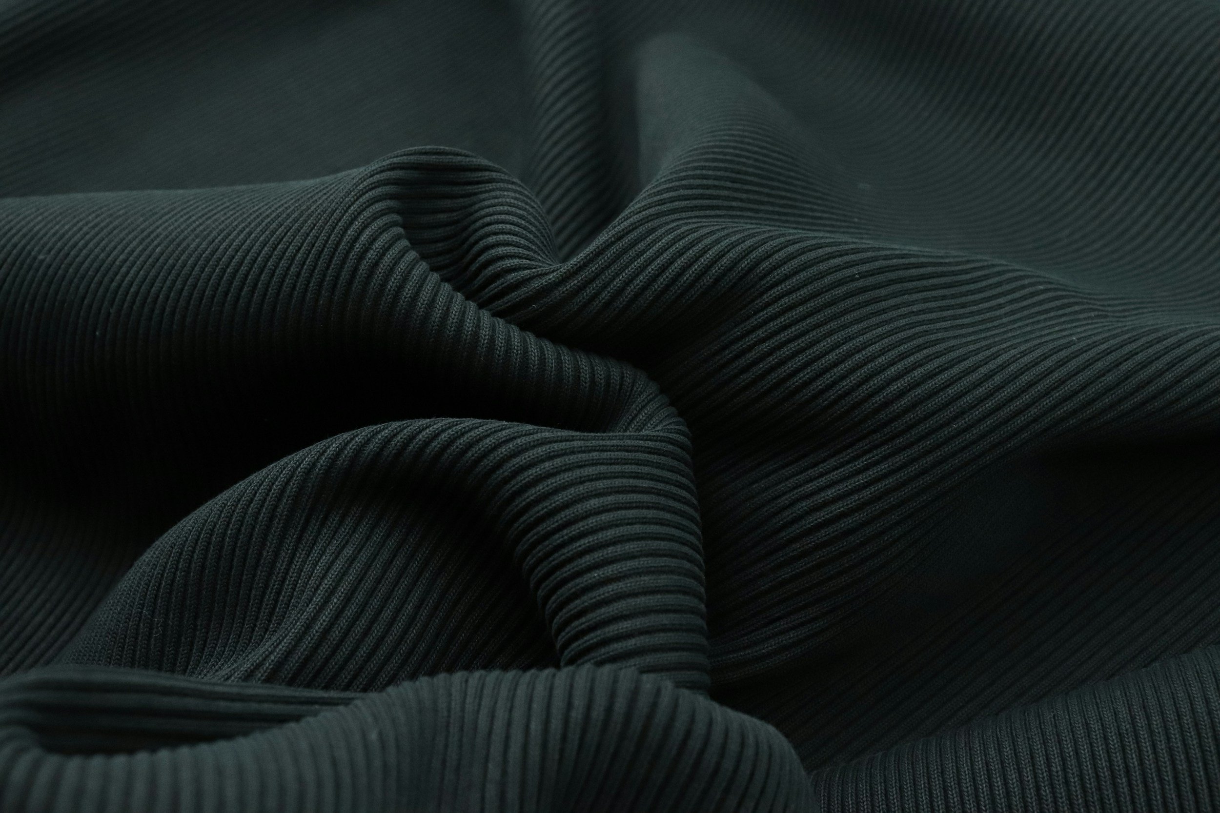Close-up of black ribbed fabric with folds and texture.