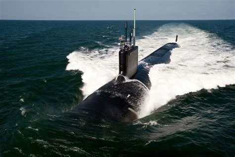 A submarine sailing in the ocean, creating a wake as it moves through the water.
