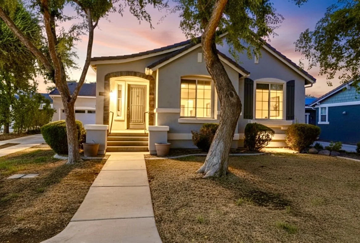This beautifully lit house exterior at twilight in Phoenix, AZ showcases inviting entryway and warm windows, captured with professional real estate photography for a welcoming presentation.