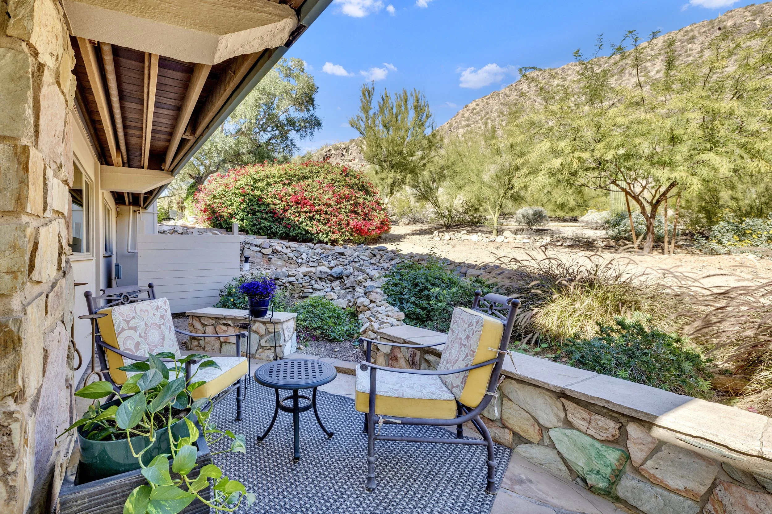 This charming desert patio seating area offers a relaxing outdoor space with mountain views in Paradise Valley, AZ, perfect for enjoying the natural surroundings, showcased through expert real estate photography.