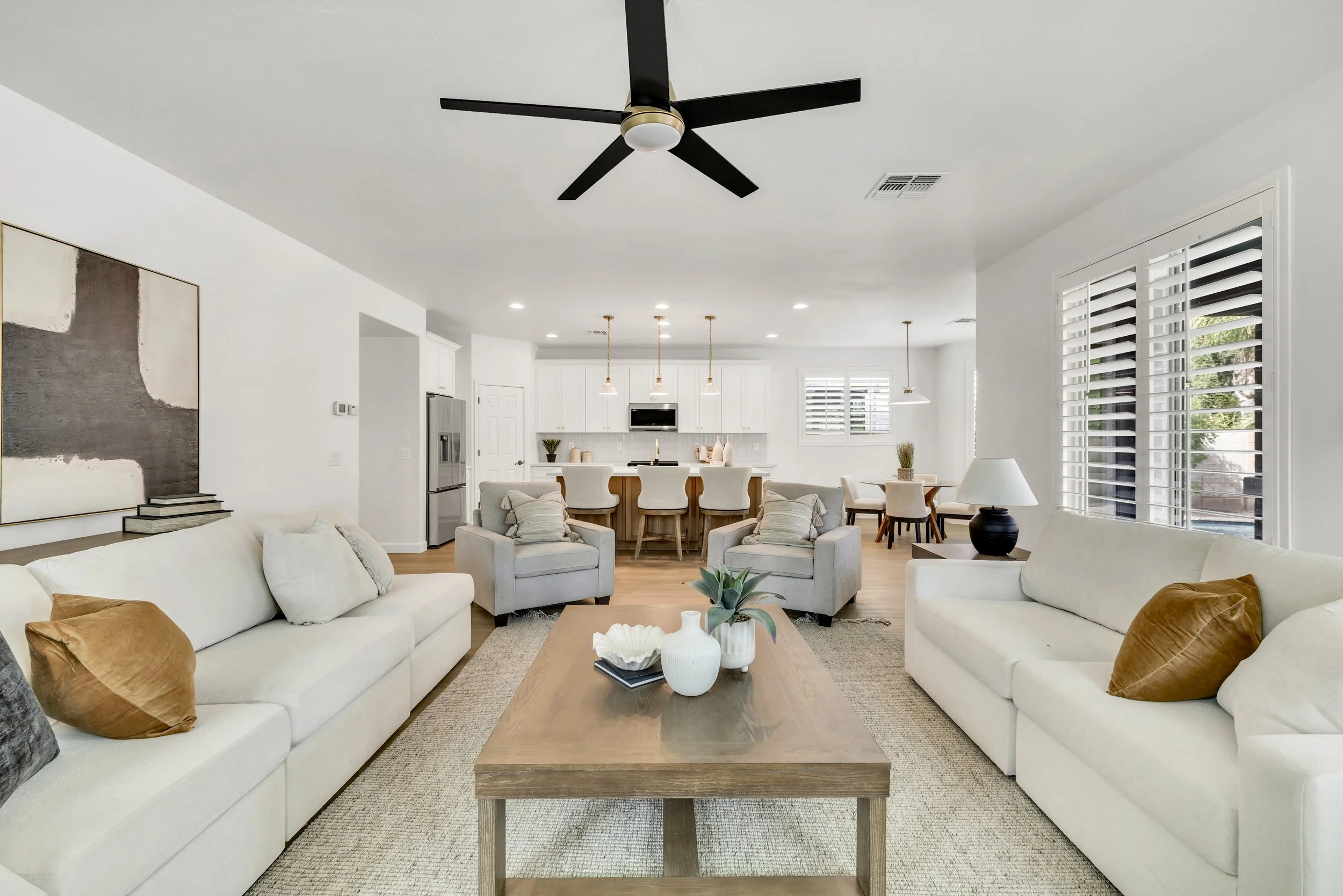 Bright open living room and kitchen interior captured in real estate photography in Morrison Ranch neighborhood, Gilbert, AZ, showcasing modern design and spacious layout.