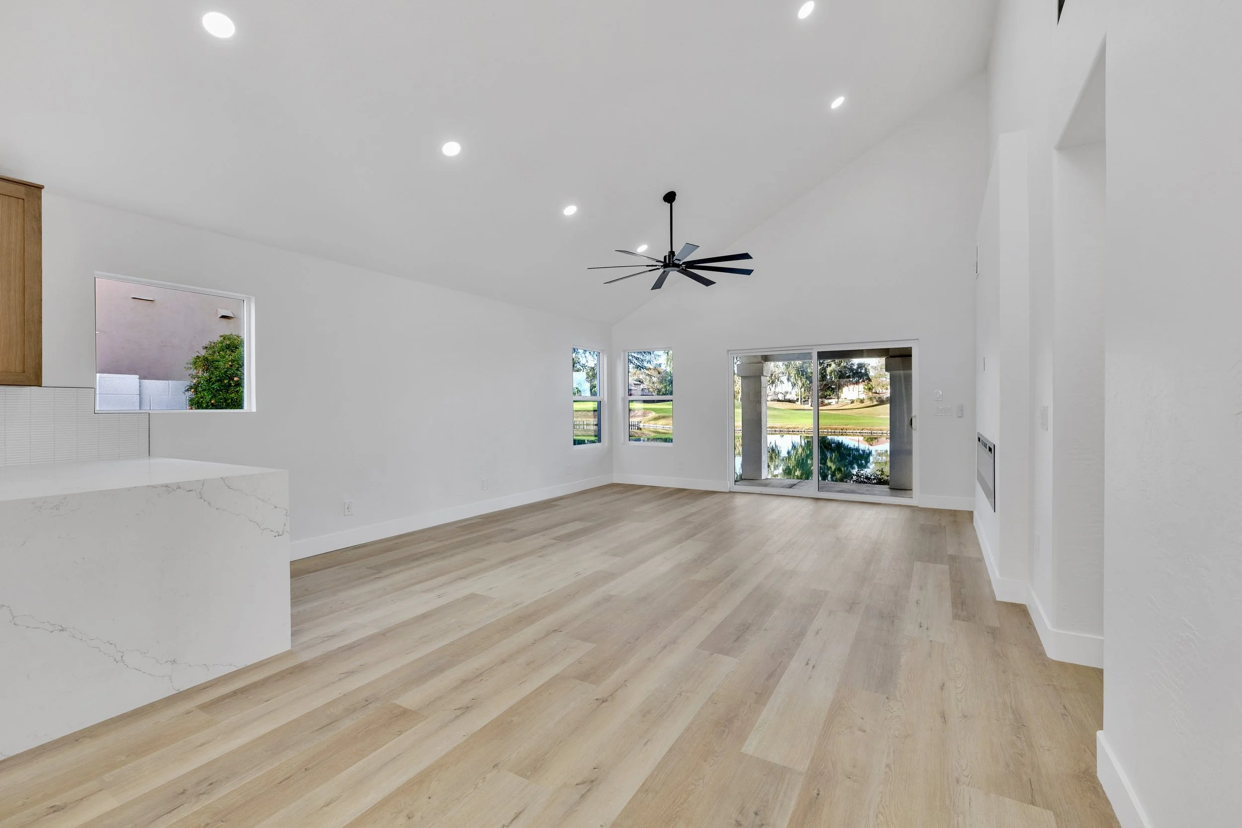 A spacious and bright empty living room with vaulted ceiling and lake views in Chandler, AZ, captured with expert real estate photography.