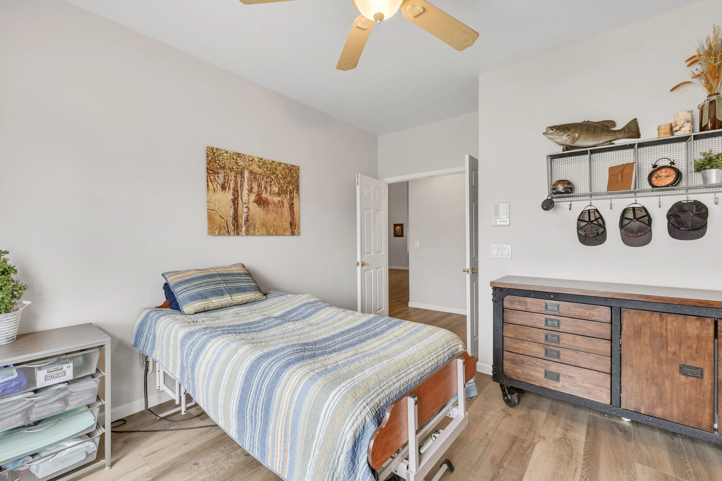 This bedroom in Goodyear, AZ showcases cozy decor and wood furniture, captured with professional real estate photography to highlight the inviting living space.