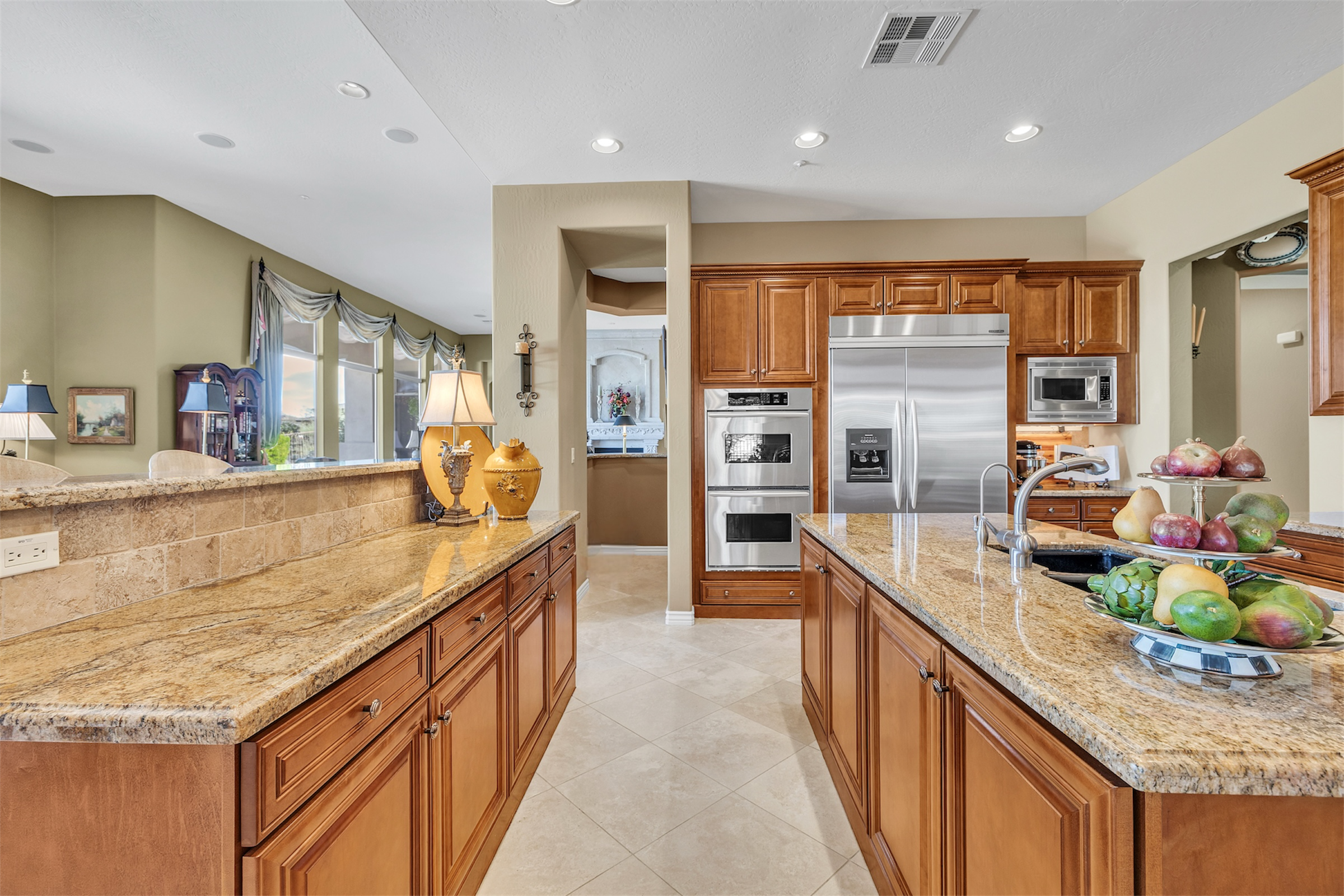 This image showcases a modern kitchen in Scottsdale, AZ with granite countertops, wooden cabinetry, and stainless steel appliances, captured through expert real estate photography.