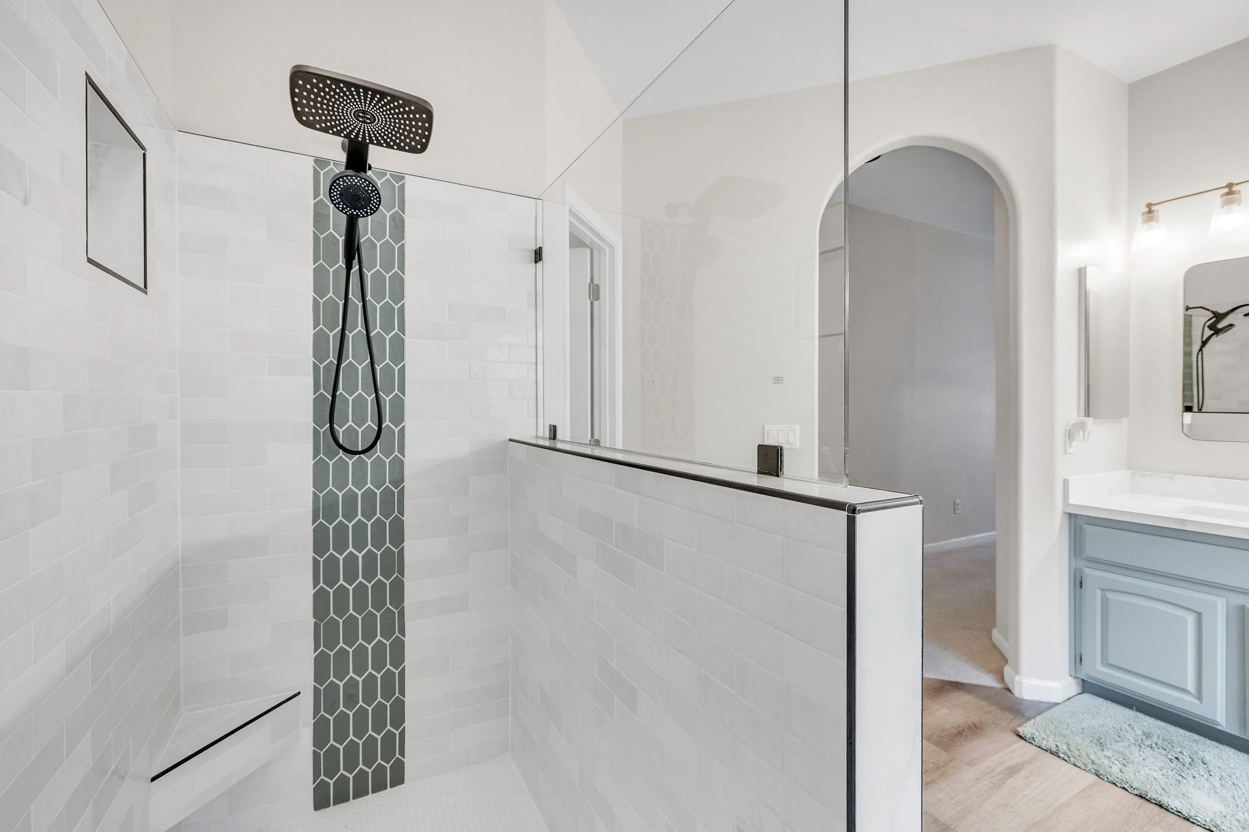 This modern bathroom with a walk-in shower features stylish tile work and a clean design in a Goodyear, AZ home, captured through professional real estate photography.