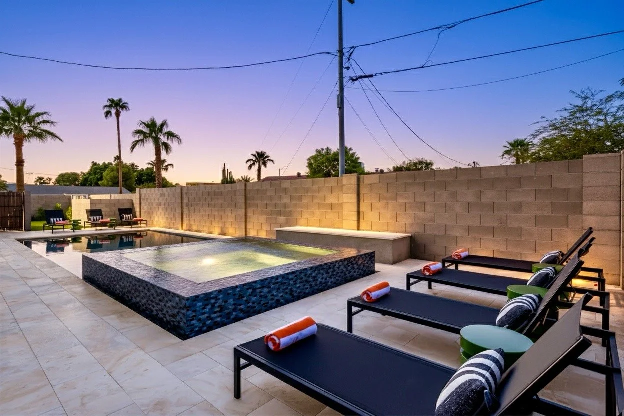 This twilight real estate photography captures a serene pool area with loungers and palm trees in Phoenix, AZ, highlighting an inviting backyard perfect for relaxation and entertaining.