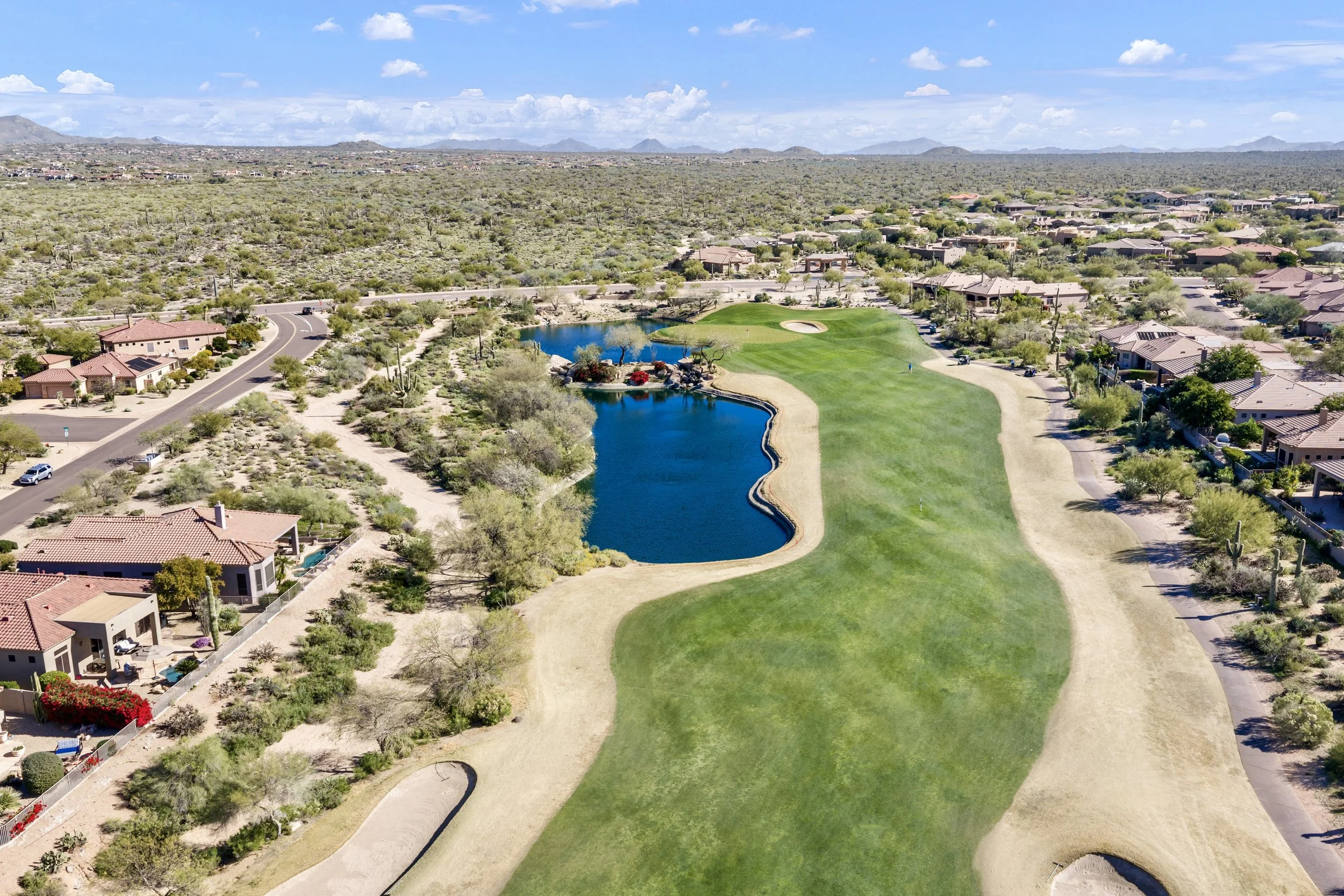 Aerial real estate photography showcasing a lush golf course and adjacent homes in Scottsdale, AZ, highlighting the beautiful desert landscape and well-maintained properties.