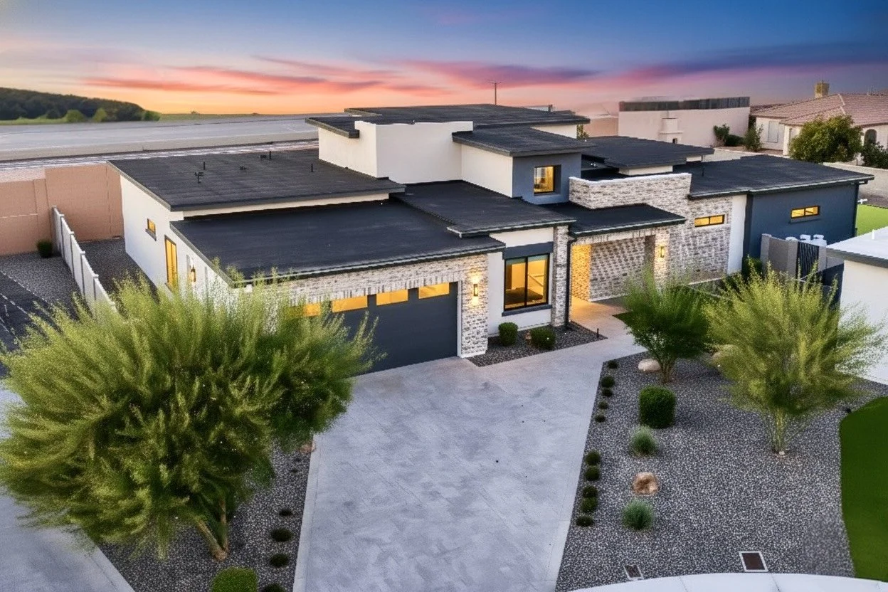 Front exterior twilight drone view of modern luxury home with flat roof design in Arizona.