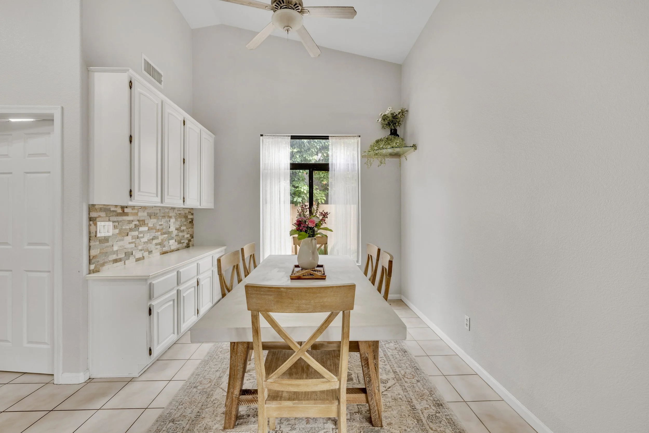 Bright and airy dining room with natural light and neutral tones showcased in this Goodyear, AZ home, captured with professional real estate photography.