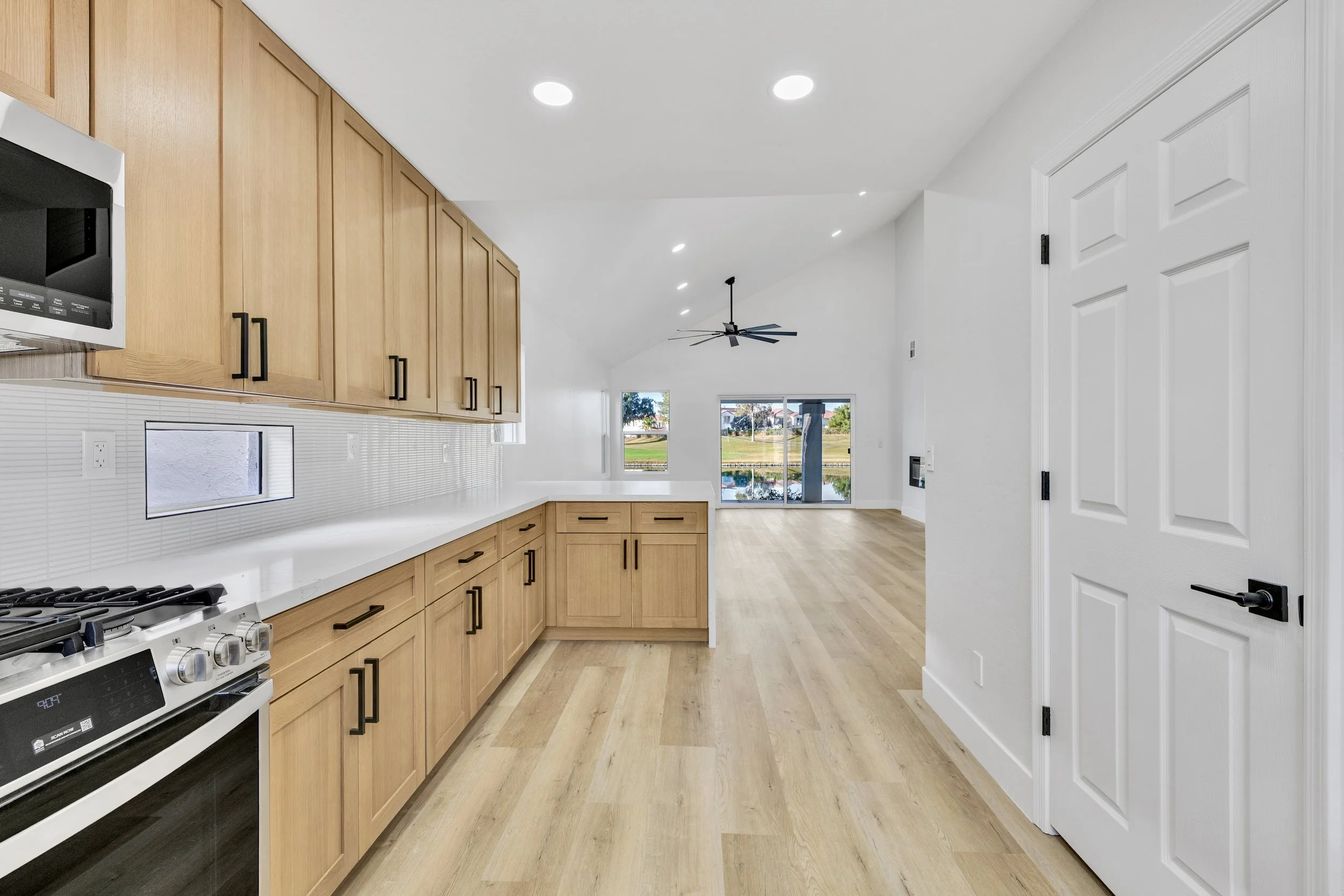 This modern kitchen and living area in Chandler, AZ features an open concept design perfect for family gatherings, captured with professional real estate photography emphasizing space and natural light.