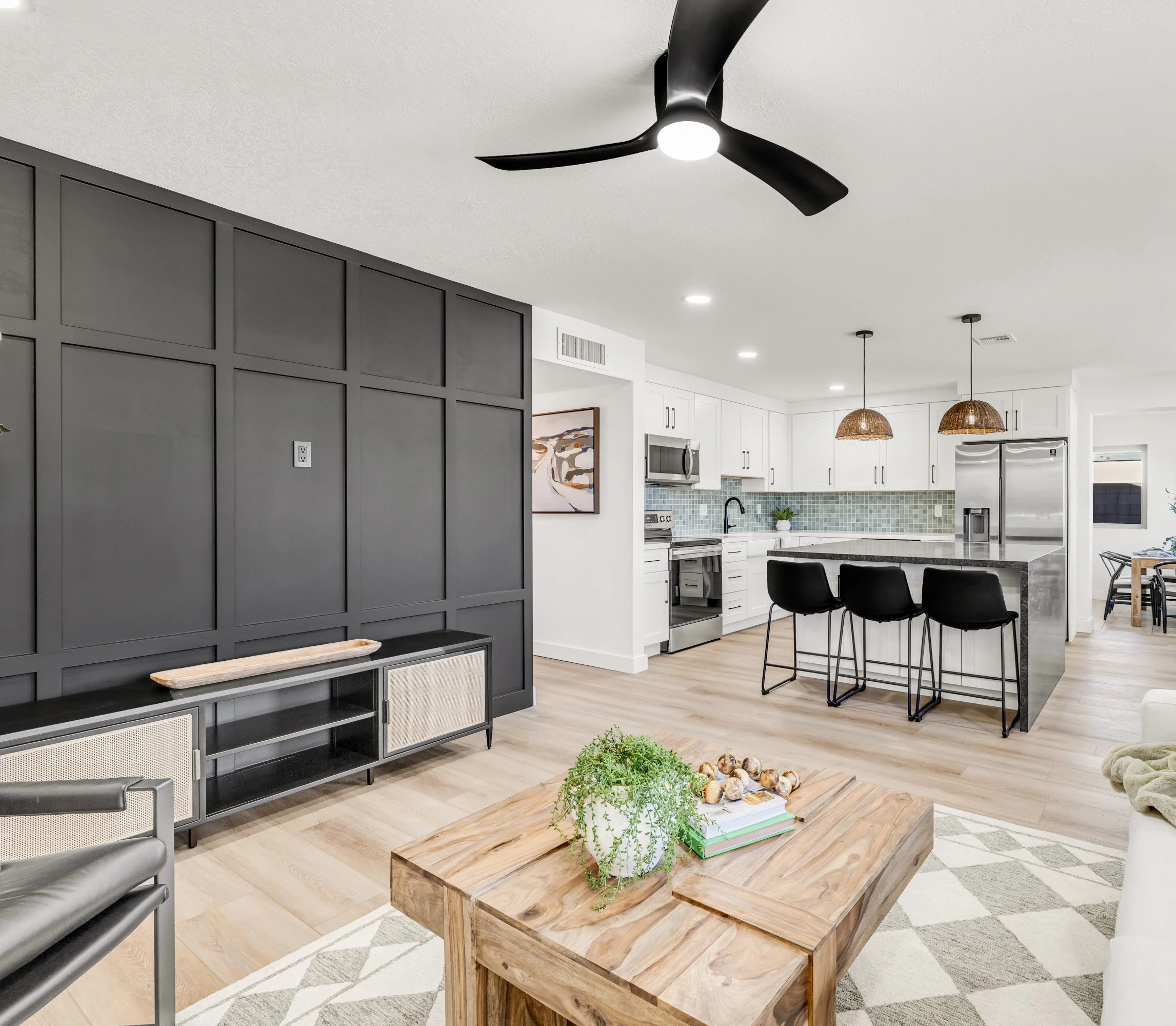 Bright modern living room and kitchen with stylish black accents and wood furniture showcased in this Mesa, AZ home real estate photography.