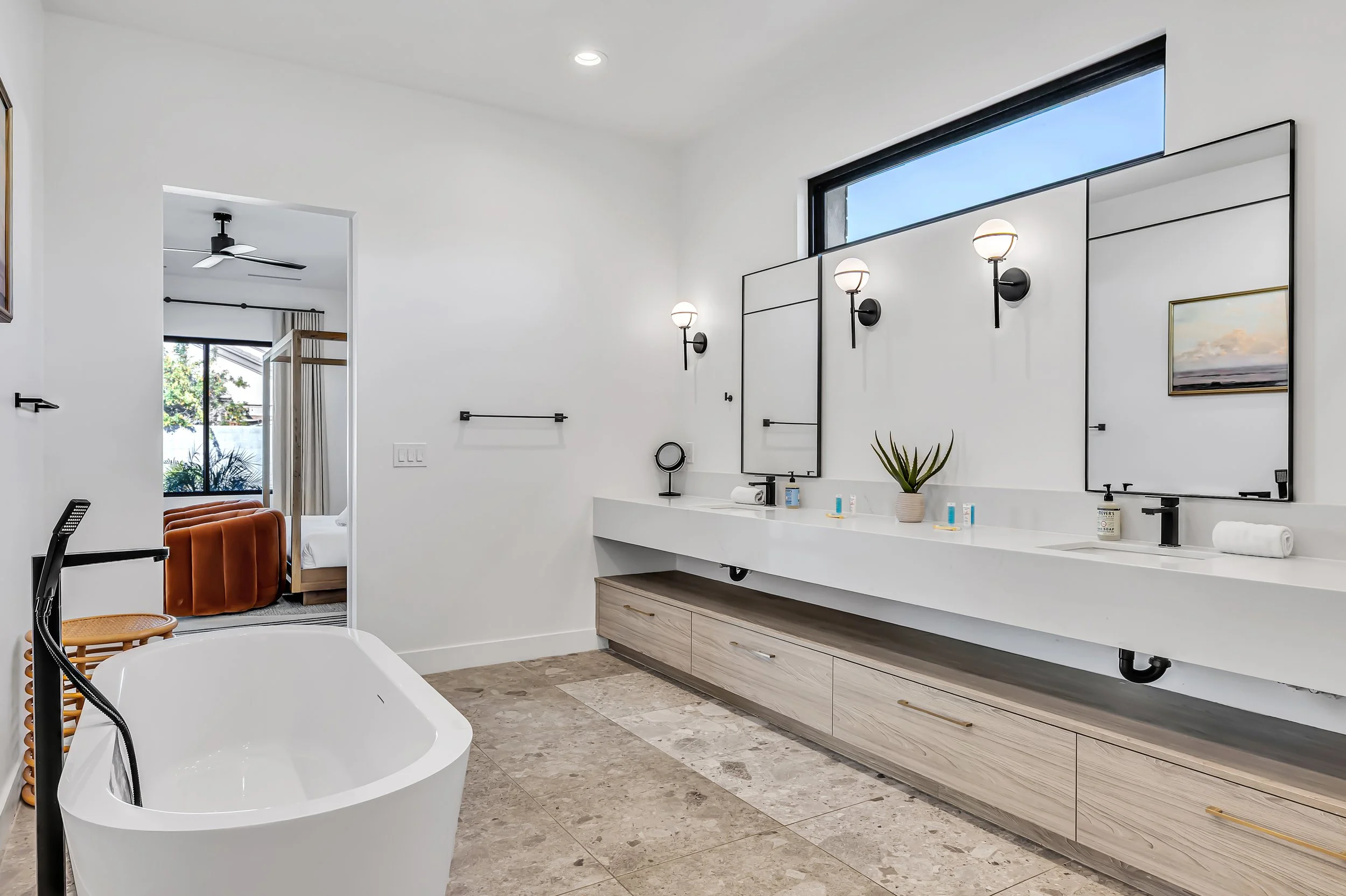 Spacious bathroom with freestanding tub, double vanity, and doorway opening to the primary bedroom in Scottsdale, Arizona.