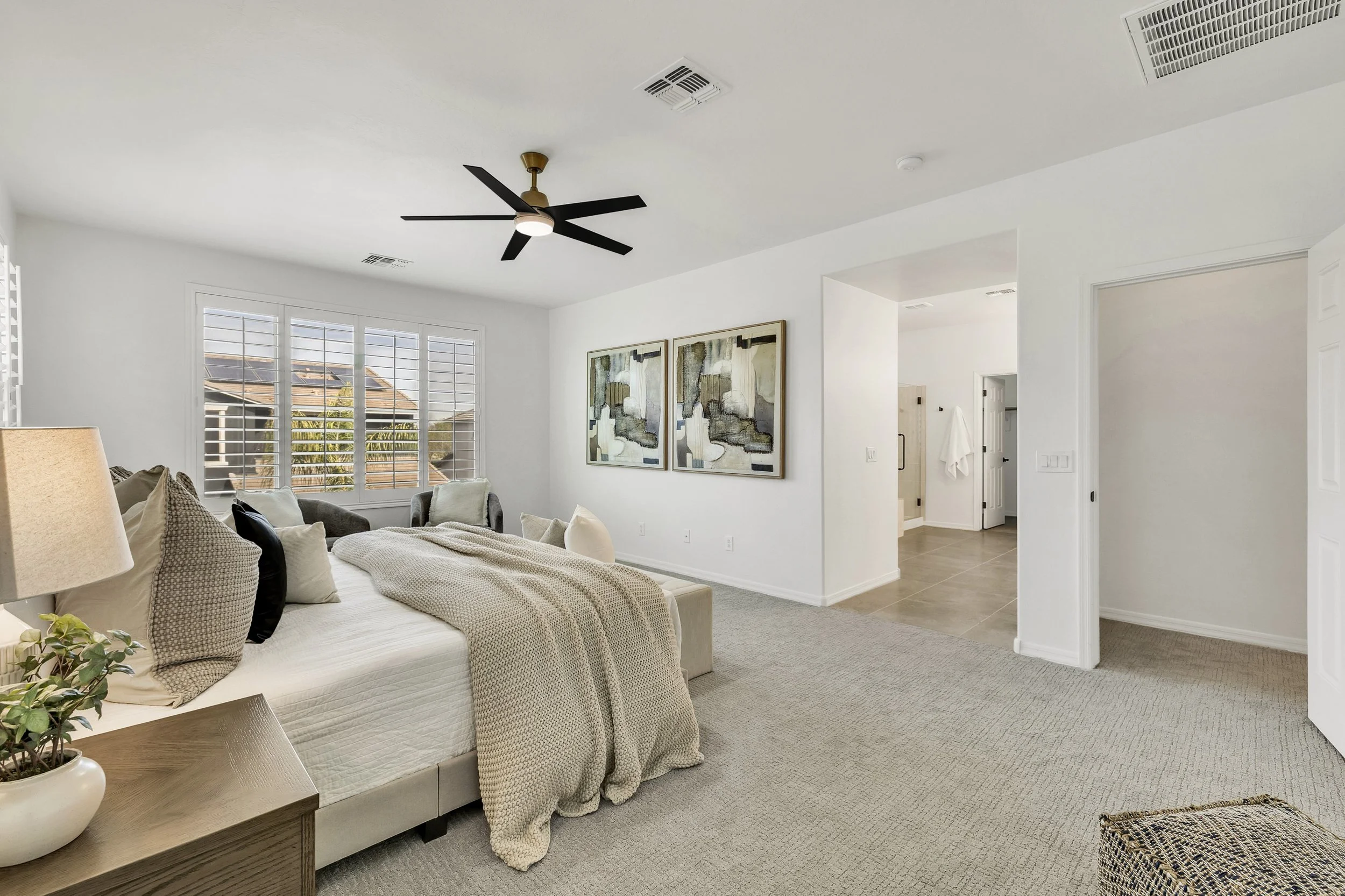 Spacious bright bedroom with ceiling fan and large window in Gilbert, AZ, showcased in real estate photography in Morrison Ranch neighborhood.