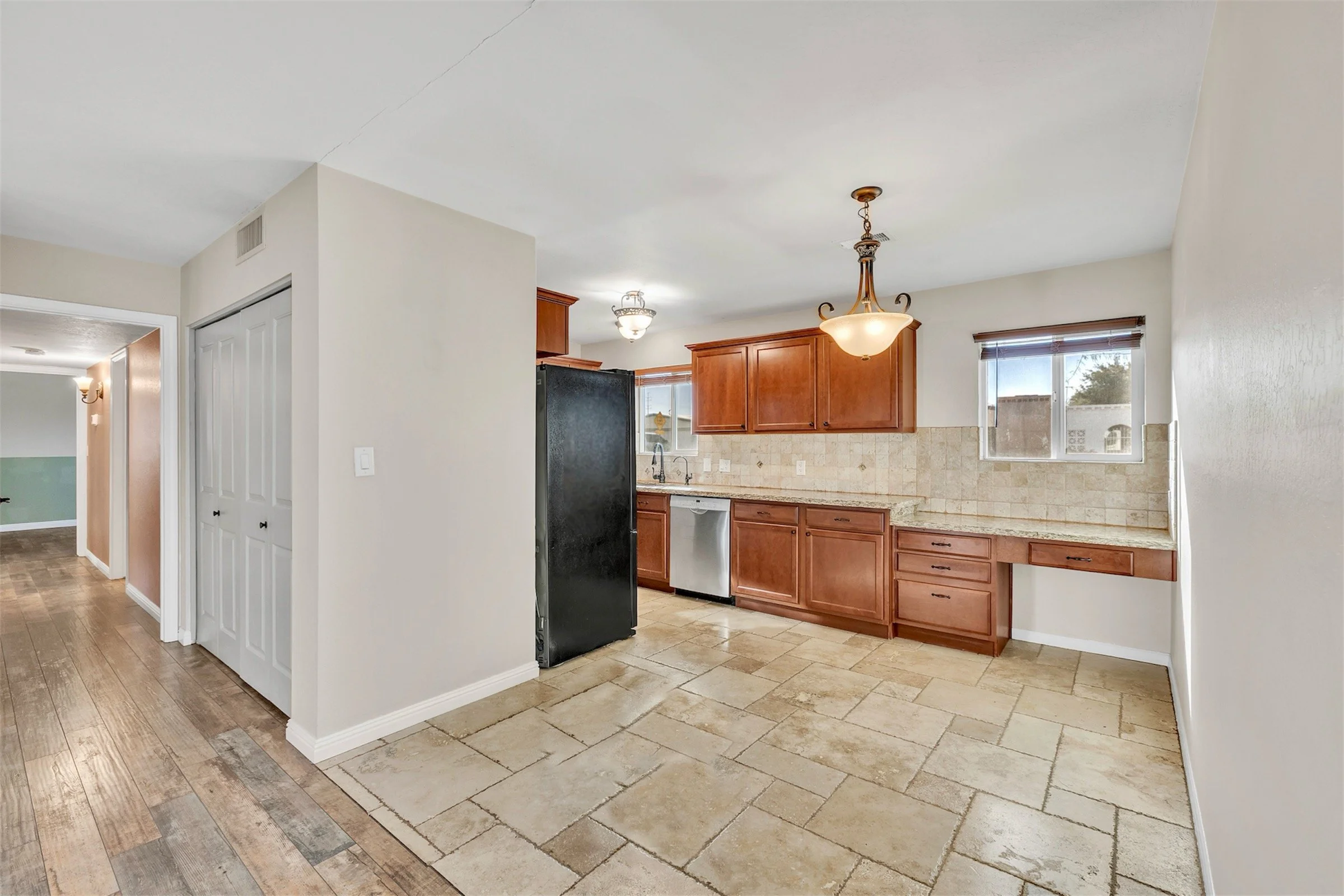 Bright kitchen with tiled flooring, wooden cabinets, and modern appliances featured in a Tempe, AZ home, showcasing excellent real estate photography for property listings.