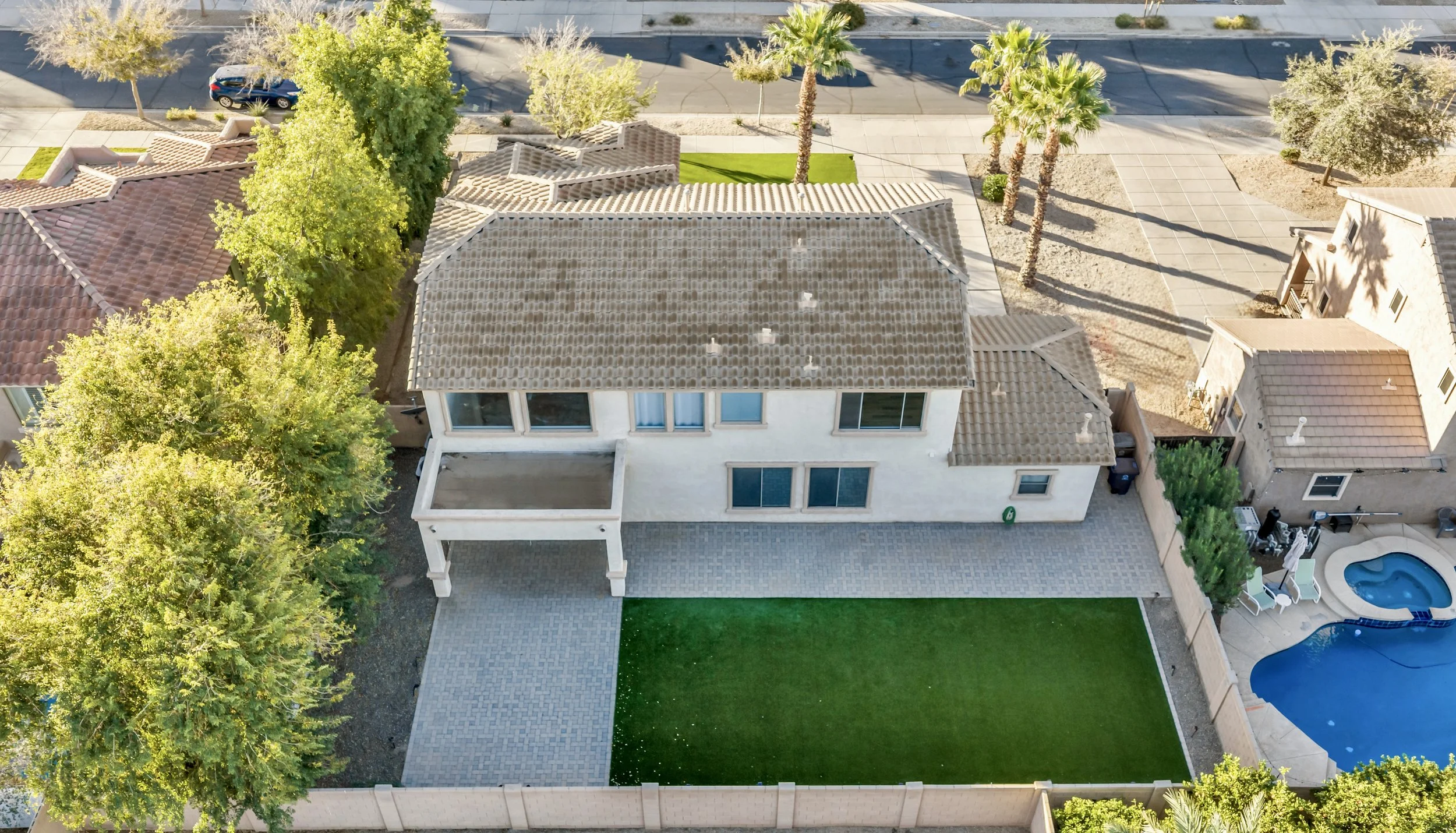 This aerial photo shows a spacious suburban house with a large backyard and patio area in Queen Creek, AZ, perfect for outdoor living and entertaining.