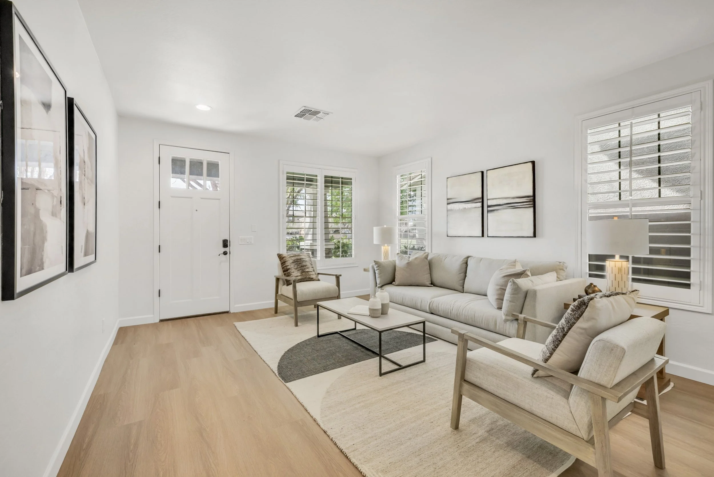 This bright living room features modern furniture and abundant natural light, presented in expert real estate photography in the Morrison Ranch neighborhood of Gilbert, AZ.