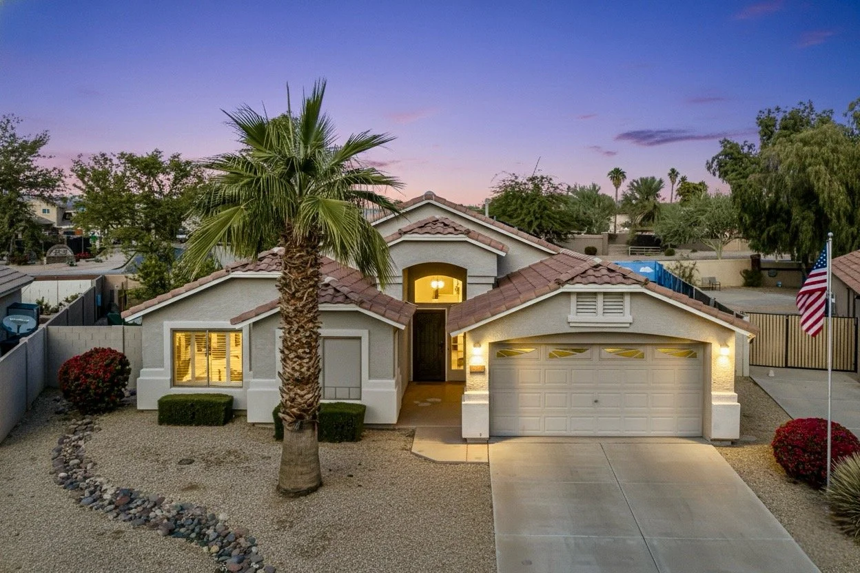 Twilight real estate photography of a suburban home with desert landscaping and illuminated windows in Phoenix, AZ.