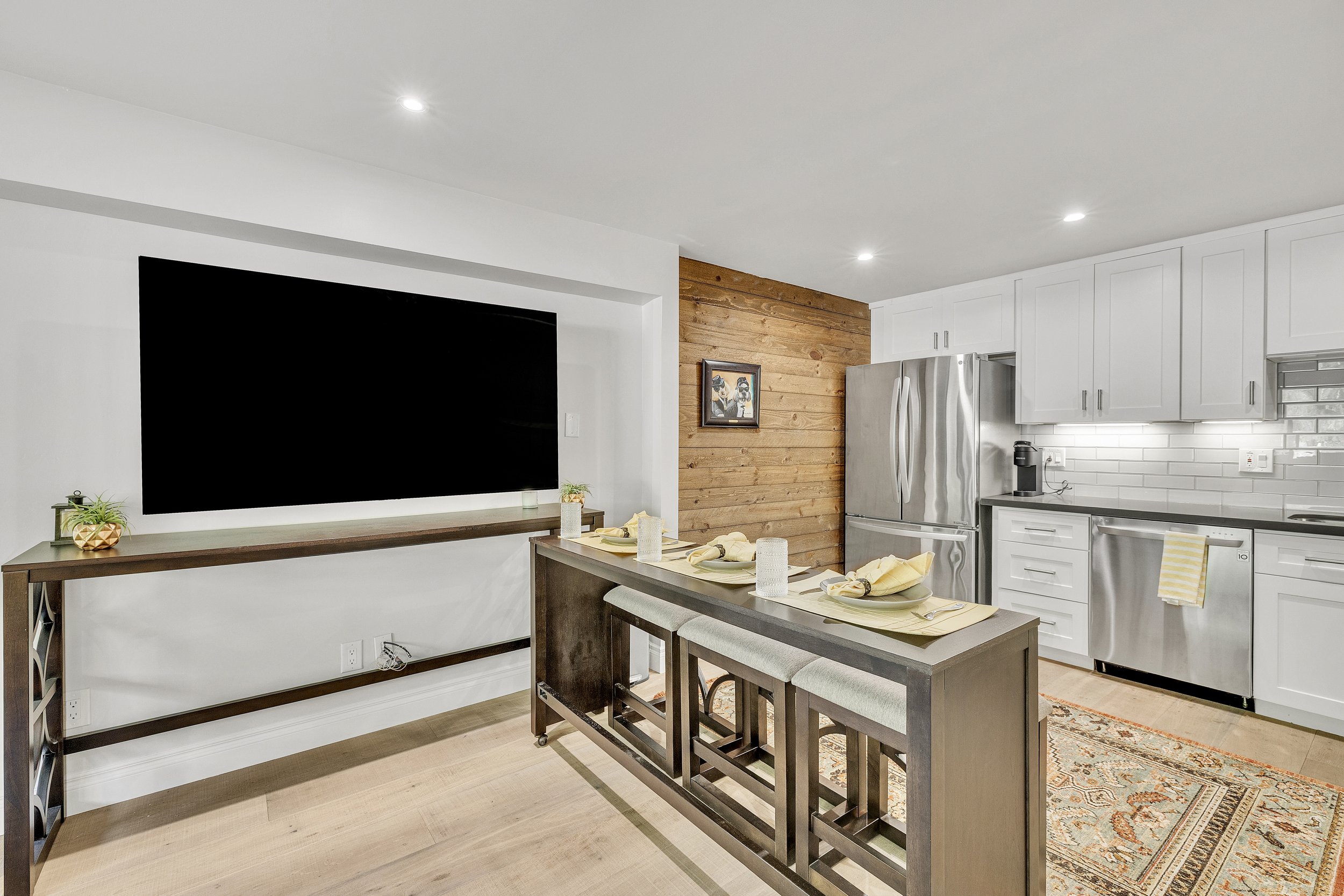 This modern kitchen and dining area in Paradise Valley, AZ features stainless steel appliances and a cozy dining space, captured with professional real estate photography for optimal showcasing.