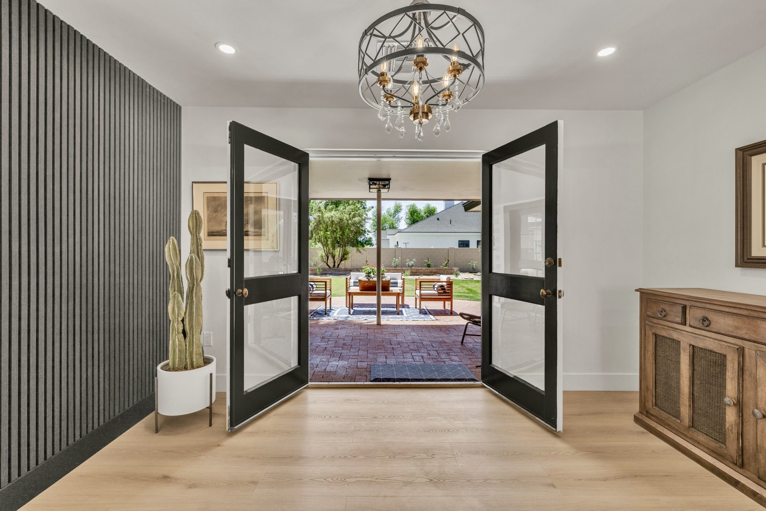 This Phoenix, AZ home features an inviting interior entryway with double doors opening to a charming patio, captured with expert real estate photography.