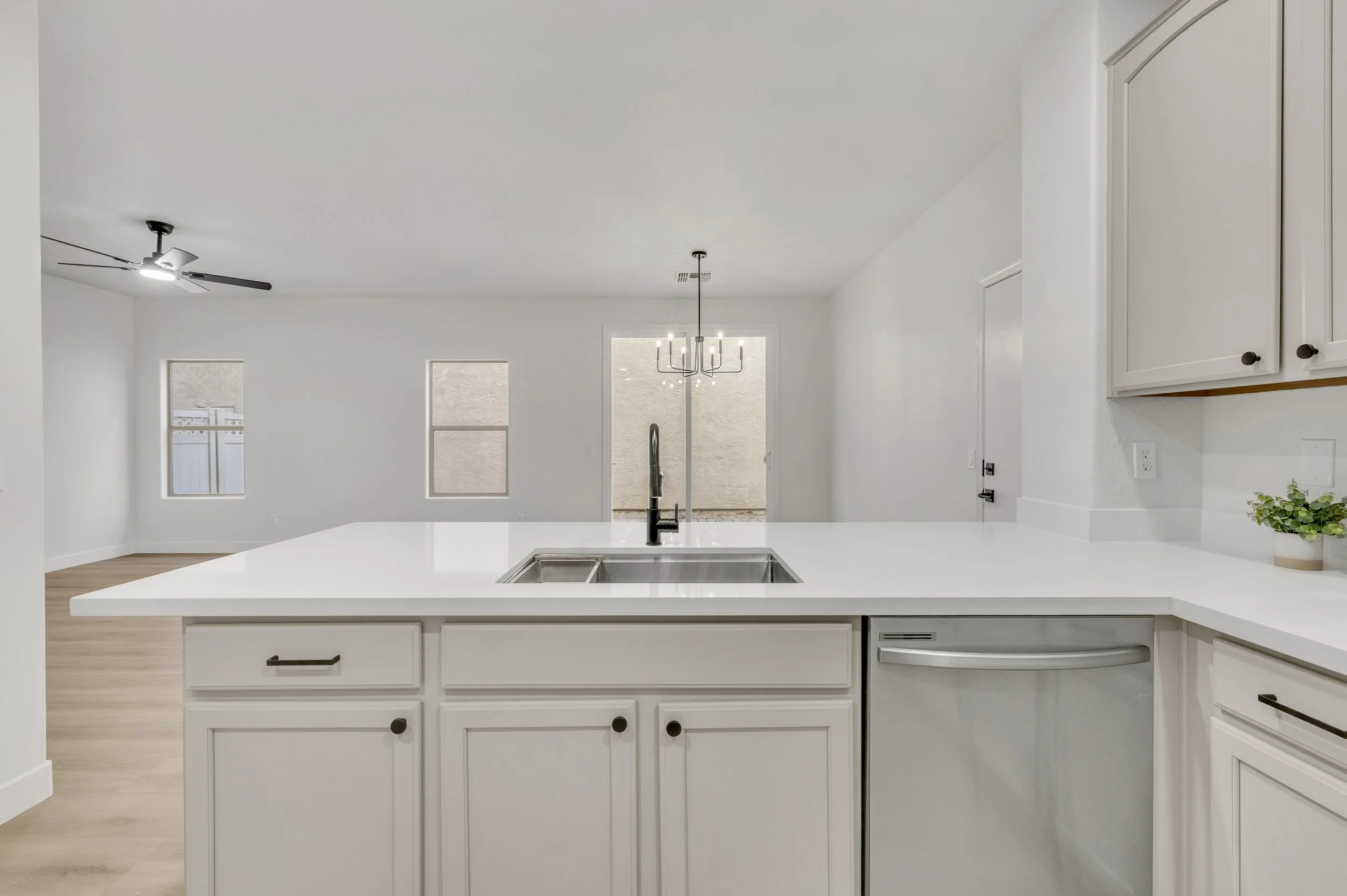 This Gilbert, AZ kitchen showcases sleek white cabinetry and modern fixtures, captured expertly through professional real estate photography for appealing home listings.