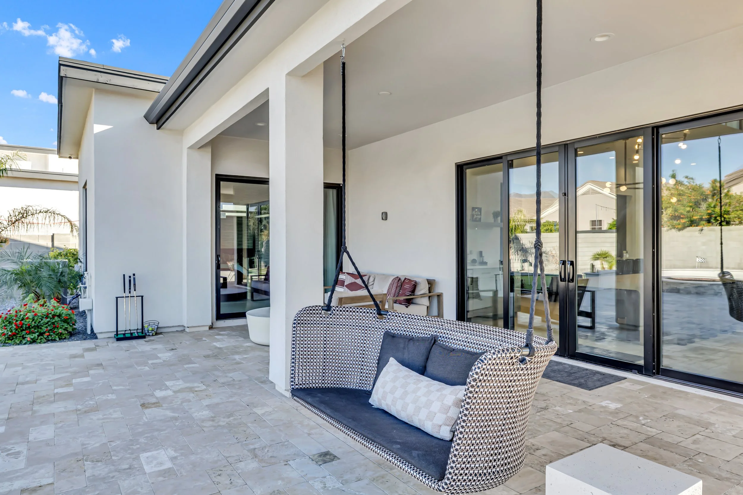 Covered patio with a hanging outdoor swing seat and sliding doors into the home in Scottsdale, Arizona.