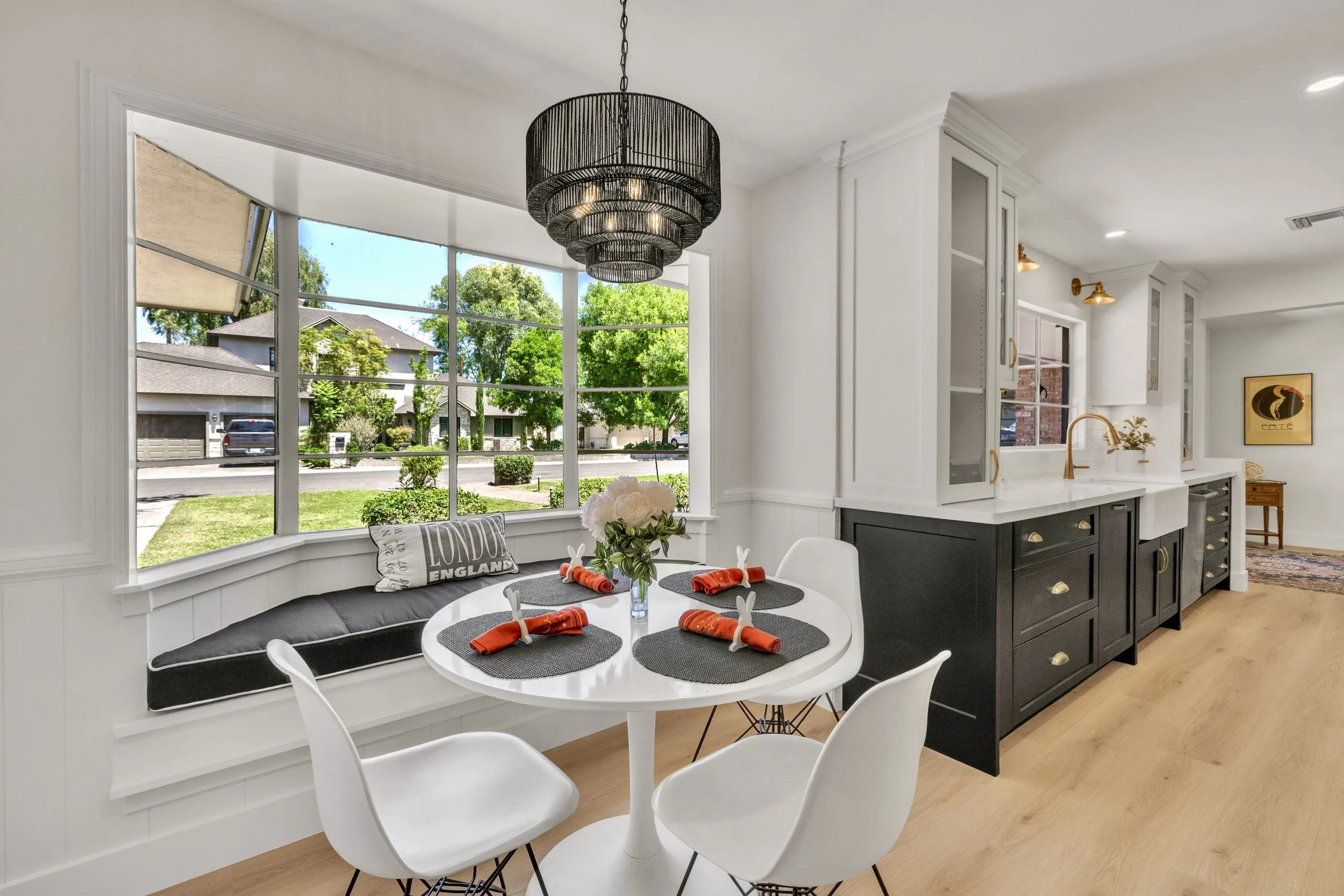 This Phoenix, AZ dining area features a large bay window and modern kitchen, captured with professional real estate photography to highlight its spacious, bright design and stylish finishes.