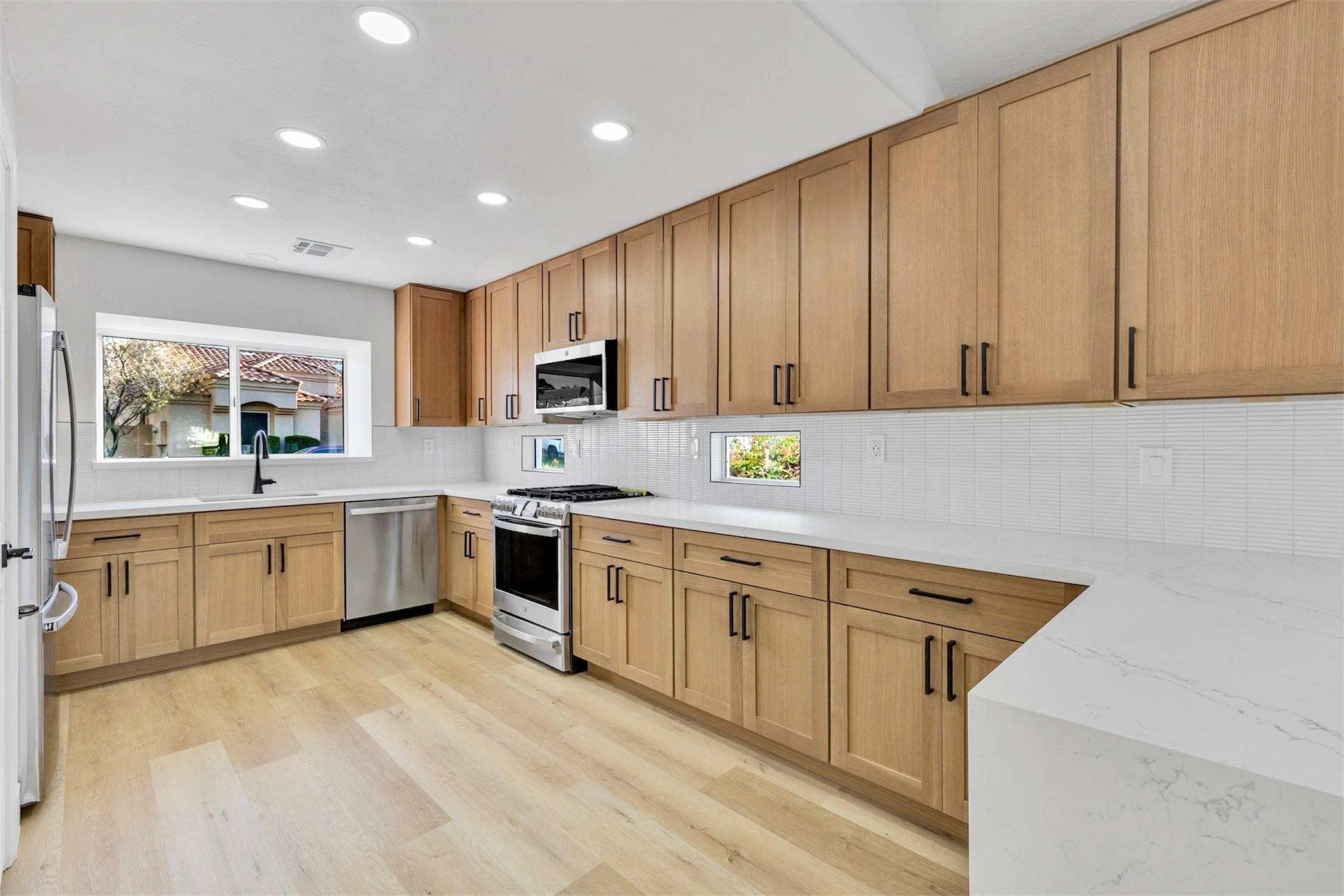 This modern kitchen in Chandler, AZ features spacious wooden cabinets, stainless steel appliances, and elegant real estate photography showcasing a bright, inviting cooking space.