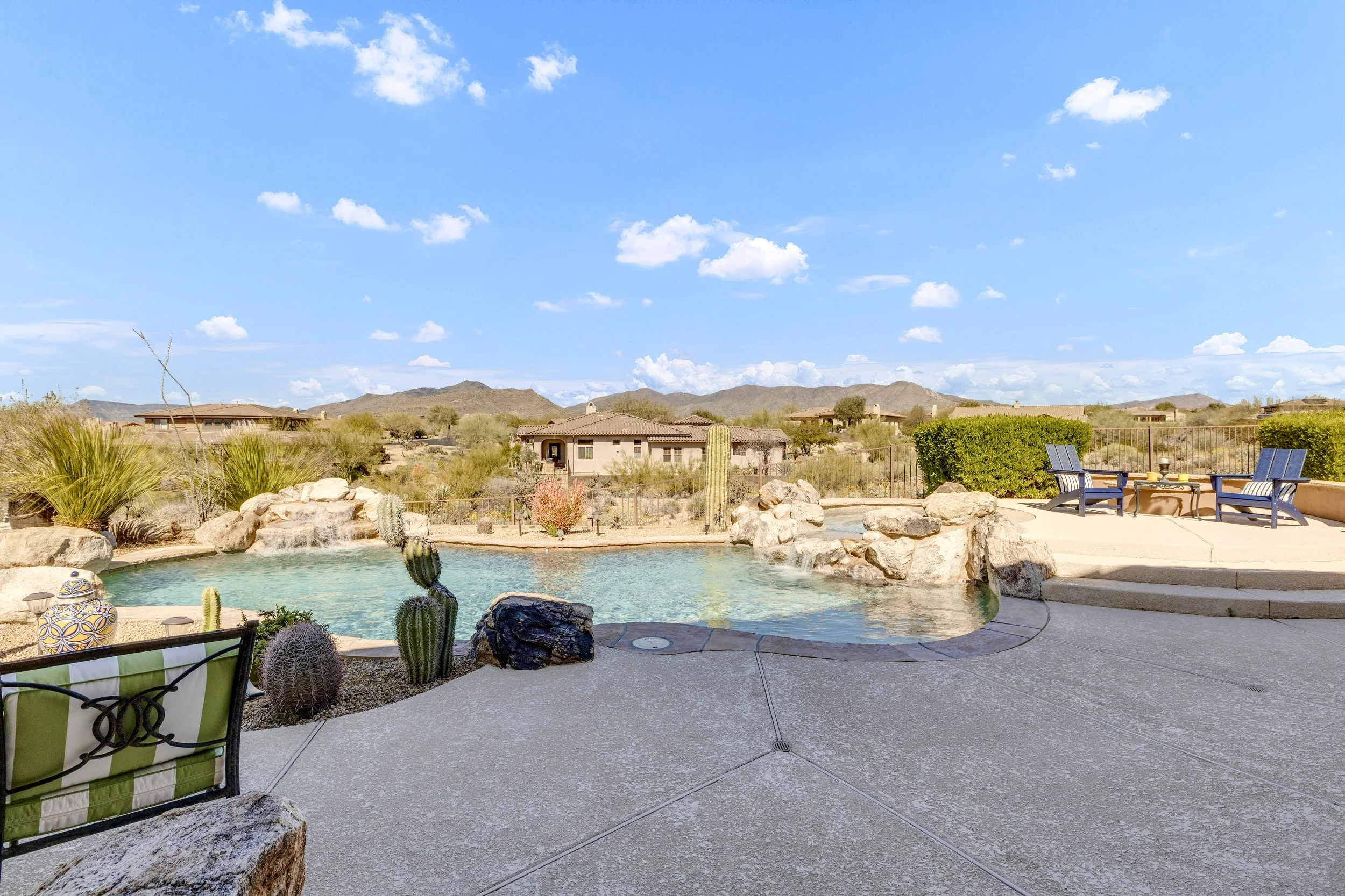 This Scottsdale, AZ backyard features a spacious swimming pool with desert landscaping and mountain views, highlighted in professional real estate photography for an inviting outdoor living space.