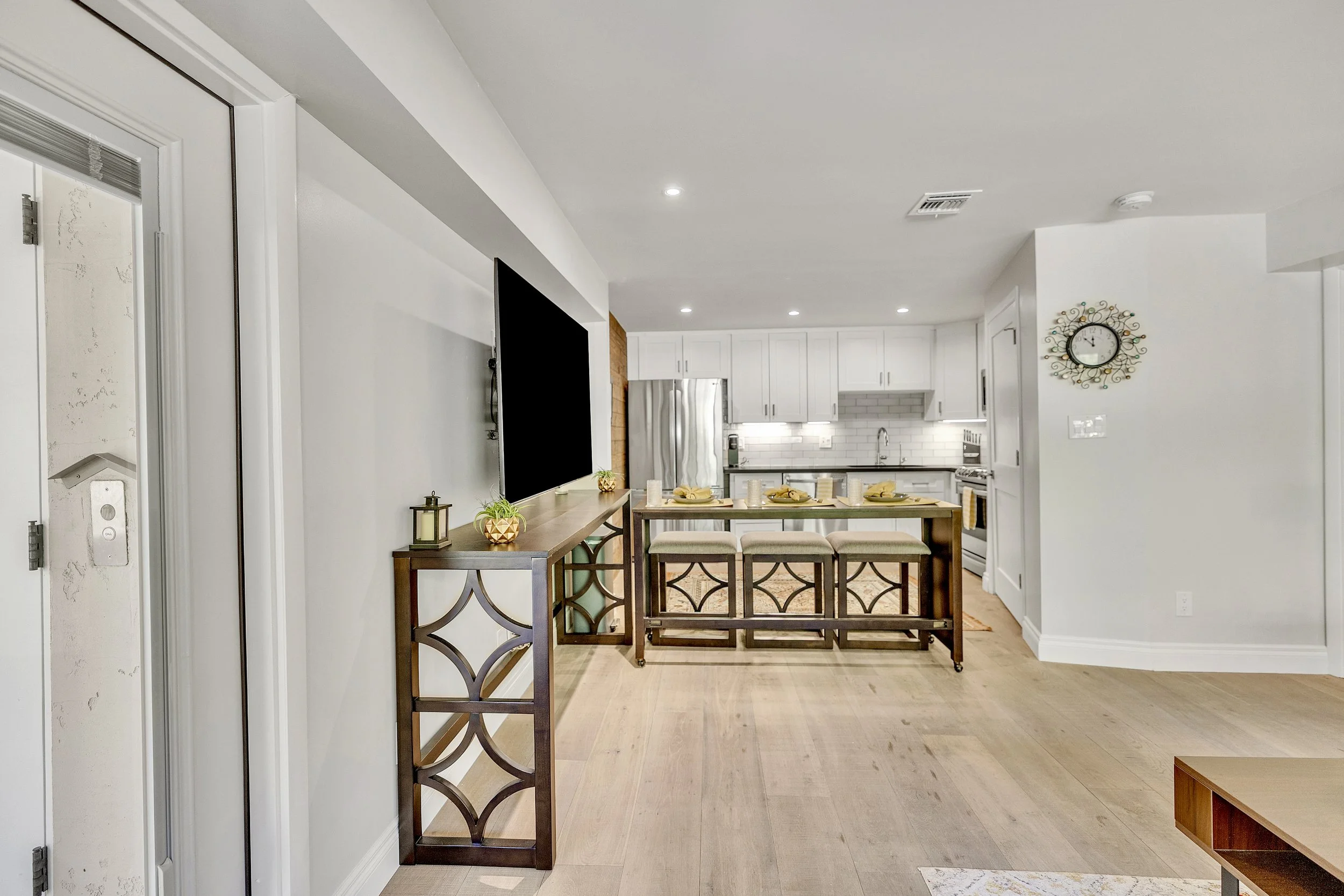 This bright interior kitchen and dining area with barstools showcases modern design in Paradise Valley, AZ, perfect for real estate photography highlighting spacious and stylish living spaces.
